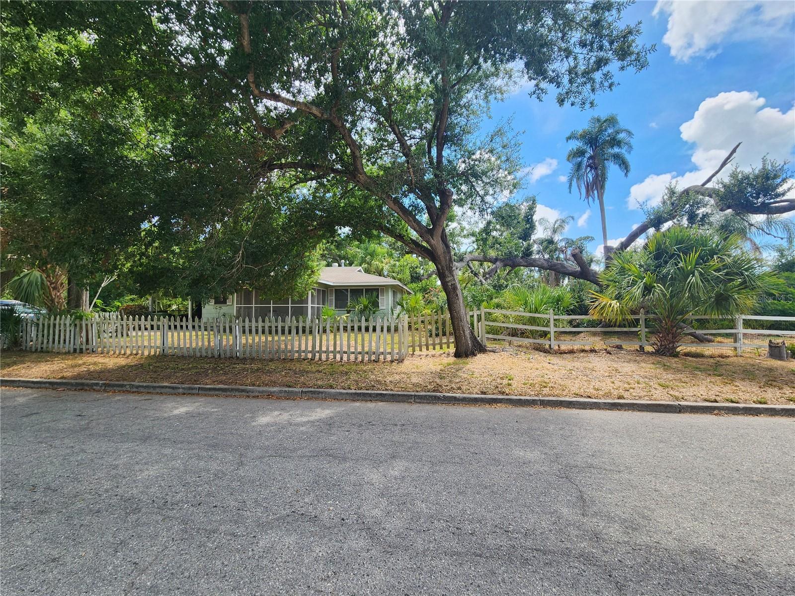 A rare opportunity to own one of West Bradenton's most enchanting homesites. Two adjacent parcels totaling 0.567 acres (approximately 190' x 130') create a remarkable canvas beneath a canopy of majestic oak trees and lush Old Florida landscaping. A charming City of Bradenton park sits just across the street, providing a peaceful backdrop where birdsong and nature are part of everyday life.

The historic bungalow has seen better days, but its hardwood floors, timeless character, and classic Florida architecture hint at the stories it could tell. Whether you choose to lovingly restore this aging home, create a private estate surrounded by mature trees, or explore the potential to subdivide and build multiple residences (buyer to verify with the City), the possibilities are truly exceptional.

The expansive property offers ample room for gardens, guest houses, workshops, or additional outdoor living spaces. Located in Flood Zone X, the seller reports no history of flooding, and underground utilities provide added convenience and peace of mind.

Ideally situated in the heart of West Bradenton, you'll enjoy easy access to shopping, dining, medical facilities, public transportation, and everything the area has to offer—all while feeling tucked away in your own private Old Florida sanctuary.