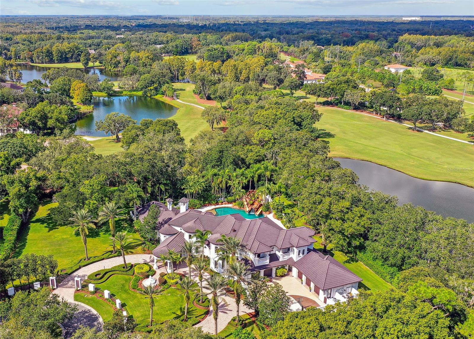 Welcome to Villa di Grotto, a sanctuary of timeless elegance inside of Avila Golf and Country Club, the most prestigious guard-gated community in Tampa Bay. This extraordinary residence, a manifestation of dreams, built by Windstar Homes, was commissioned by New York Yankees baseball legend, offering an unparalleled blend of sophistication and natural beauty, complemented by captivating views of the serene lake and the pristine golf course. Recently updated to embrace the conveniences of modern living, this home boasts smart home technology, allowing you to effortlessly oversee the entire property with a simple touch or the gentle swipe of your hand. The updated kitchen, adorned with exquisite Italian porcelain countertops including a waterfall island harmoniously blends functionality with aesthetics, while the fresh interior and exterior paint add a contemporary look. Upon arrival at the end of a cul-de-sac greeted by double gates, a circular driveway, fountain and a porte cochere, you will feel a warm and distinguished welcome. Sprawled across 2 generous acres, this property offers a canvas of limitless possibilities, ample space to expand and host the grandest of events. As you step through the threshold, a double-height foyer highlights the architectural brilliance and meticulous craftsmanship that define this home offering views of the grand resort style pool and grotto with covered jacuzzi and water slides.  Every facet of this residence, from its chosen finishes to its designed open layout, emanates an aura of sophistication and refinement. Immerse yourself in the coveted Avila lifestyle, a few feet away from the clubhouse where golf enthusiasts can perfect their swing and relish the club's amenities such as the pool, tennis courts and fitness center. Moreover, this property bestows upon you the invaluable gifts of privacy and security, ensuring your peace of mind within this exclusive community. Located a brief 25-minute drive from the heart of downtown and Tampa International Airport, to simplify your travel needs. Villa di Grotto represents a rare opportunity to own a piece of history, one-of-a-kind home. Where sophistication, privacy, and safety intertwine in a harmonious symphony to call home.