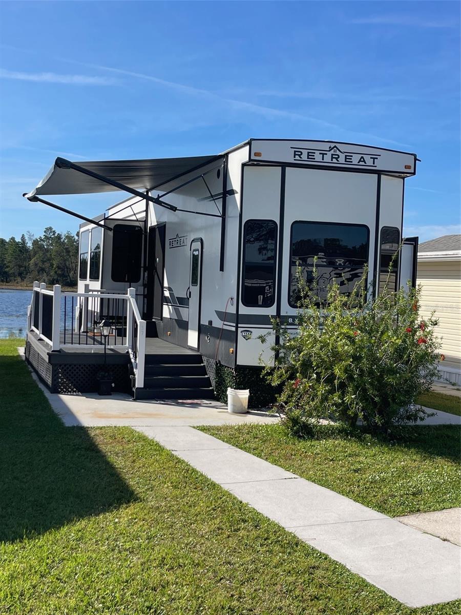 ATTENTION!! LOT and TRAILER can be SOLD Separately. Call for details. LAKEFRONT LIVING! RETIRE WITH CONFIDENCE!! Welcome to Kove Estate, a 55+ Co-Op community, a friendly active environment offering resort-style living in a gated Golf community. This lakefront 2023 Keystone Retreat features a Primary Bedroom with built in cabinets and nice size closet. Additional sleeping quarters (Loft) and storage upstairs perfect for overnight guest. 1 Full Bathroom with Walk in Shower and additional storage, a spacious Open Living Room, Dining room Kitchen area. Kitchen features, Gas Range, Microwave, Oven, nice size Refrigerator/Freezer and closet pantry. Living Room features a sleeper sofa, built in TV console with Electric Fireplace. Beautiful new Deck overlooking Little Lake. Wash/Dryer combination. Plenty of parking for your and your guest. As a resident of The Kove Estate, you will enjoy free 9-hole golf, two pools (one heated), tennis courts, pickleball, community events, Clubhouse, Library, and Gated security. The community is conveniently located off SR415, minutes to Sanford, Deltona, New Smyrna Beach, close to shopping, dining, medical facilities, and attractions such as the Daytona International Speedway, the Kennedy Space Center, and the Orlando theme parks. The Keystone unit itself can be financed call for details. This is a perfect spot for a peaceful and convenient lifestyle. Trash, Sewer and trash pickup is included in the LOW HOA. There is no lot rent, as a share in the community conveys with the sale. Call today to view!