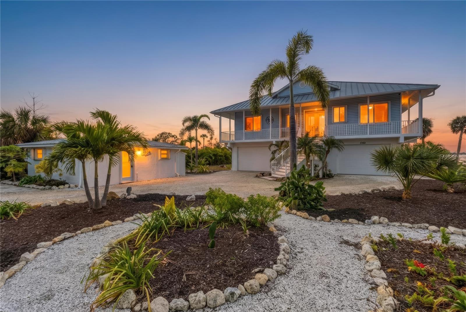 Welcome to your private WATERFRONT sanctuary in a sheltered cove just off of Lemon Bay—an extraordinary custom-built Key West-style residence with BREATHTAKING VIEWS. Perfectly positioned to capture the beauty of Southwest Florida, this home offers the ultimate blend of serenity, comfort, safety, and elevated coastal living in a sheltered bay with very low boat traffic. 
From the moment you arrive, you’ll be captivated by the home’s breezy island ambiance, where light-filled interiors and thoughtful design create a seamless flow for everyday living and elegant entertaining. Step through the double entry doors into an inviting space featuring soaring 10-foot ceilings, timeless coastal finishes, and an open-concept layout designed to showcase the water views. The spacious great room and kitchen includes granite countertops, updated custom Kraft Maid cabinetry, and effortless sightlines to the sparkling water beyond. A versatile bonus den/third bedroom provides ideal flexibility for guests or a home office.
Step outside to experience your own backyard oasis featuring an enclosed, heated saltwater pool (2022) surrounded by lush tropical landscaping, a natural-scape waterfall with GROTTO SEATING, along with a fire pit and multiple areas to lounge or dine—perfect for embracing the indoor-outdoor lifestyle Florida is famous for.
For boating and water enthusiasts, enjoy direct access to the bay (navigable in high or low tide) for sunset cruises or fishing. The property also features a newer seawall (2021) and a lower boat launch for paddle boards and kayaks for more unforgettable days on the water. A brand new composite dock and 10,000 LB BOAT LIFT (2025) are ready for use and relaxing.
This property is as functional as it is beautiful, featuring two tandem garages with space for up to FOUR vehicles, plus additional storage for beach toys and watercraft. Bonus rooms add extra space for hobbies, fitness, or workshop needs. The beautifully remodeled GUEST HOUSE provides endless possibilities including an in-law suite, art studio, or INCOME PRODUCING short-term rental.
MOVE-IN READY and extensively upgraded with over $200,000 in renovations, this home also delivers exceptional peace of mind. Built in 2001 by a highly reputable builder under newer Florida building codes, it sits approximately 14 feet above sea level and has SUCCESSFULLY weathered recent hurricanes. The home is supported by deep-set concrete pilings engineered to withstand up to 10 feet of soil erosion, providing added confidence for coastal living. Additional highlights include easy to use accordion hurricane shutters and a seamless metal roof.  Just minutes to the beach, local restaurants, shopping, golfing, biking trails, beach yoga, and the weekly farmers market on historic Dearborn Street—this is a lifestyle of ease, beauty, and effortless luxury!
Whether you’re seeking a full-time waterfront residence, a second-home retreat, or an income-producing coastal getaway—this one is truly unforgettable. Schedule your showing today!