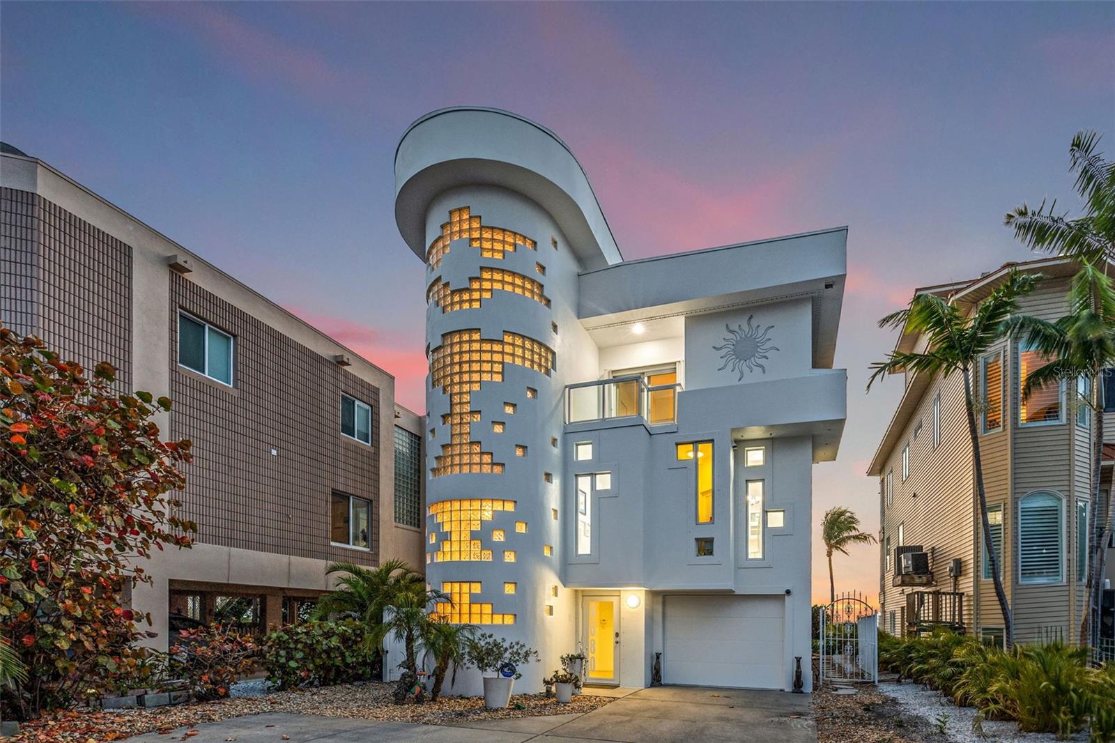 Sunset Beach's iconic "Glass Block Home," envisioned by renowned architect Daniel Thayer Dawson, now graces the market, offering a rare opportunity to own one of the West Coast of Florida's most uniquely designed residences.

Nestled along the pristine shores of the Gulf of Mexico, this ultra-modern three-story masterpiece stands tall with its distinctive 20-foot floor-to-ceiling windows, redefining coastal elegance with sleek lines, minimalist design, and cutting-edge architecture.

Step inside to experience a seamless fusion of form and function. The living room's expansive 20-foot tall windows flood the interior with natural light, providing breathtaking views of the azure waters and golden sunsets that stretch across the Gulf of Mexico. The open-concept layout creates an airy ambiance, perfect for relaxation and entertainment alike.

The kitchen beckons culinary enthusiasts with its state-of-the-art induction cooktop, custom cabinetry, and seating for four guests at the kitchen counter, making it ideal for gatherings. Meanwhile, the spacious living area, adorned with 20-foot high ceilings and designer finishes, offers the ultimate setting for hosting guests or luxuriating in comfort.

Retreat to the serene master suite, where tranquility awaits amidst sweeping ocean vistas. Wake up to breathtaking views and unwind in the ensuite bath, complete with a walk-in shower. Step outside the Master to its own private porch to enjoy sunsets or gaze at the full moon as it reflects off the waters of the Gulf. A floating glass walkway, with its own stunning water views, provides access to the third-floor guest bedroom, boasting its own incredible beach views. The home's additional bedroom is also located on the third floor.  Each of these bedrooms has its own ensuite and private porch with stunning views, providing comfort and privacy for family and guests.

Outside, a private beach oasis awaits, offering opportunities to lounge on the home's many expansive, sun-drenched decks, each adorned with custom glass railings to preserve the stunning views. Or, dine alfresco under the stars. With direct access to the beach, every day feels like a vacation in paradise.

Adding to the allure, a magnificent glass elevator seamlessly connects all three floors of the home, enhancing both convenience and luxury. On the ground floor, a freshly painted two-car garage with new two-part epoxy commercial coating awaits, along with a generous home gym room and ample storage space. Exiting from the rear garage door, you'll find a beautiful lanai providing access to both the beach and a spiral staircase leading up to the main living levels.

Just a two-minute walk up the beach, you'll find yourself at the renowned beachfront Caddy's Restaurant. Additionally, you can enjoy the vibrant atmosphere of the famous Ka'-Tiki Bar/Restaurant, which has been offering live music 7 days a week for the past 32 years. By the way, their cheeseburgers are only $3, so you'll save money eating out here!  So, whether you're seeking a tranquil beach experience or craving something a bit more lively, this home's location is perfect for both preferences. Book your private appointment today to tour Sunset Beach's own Glass Block House.