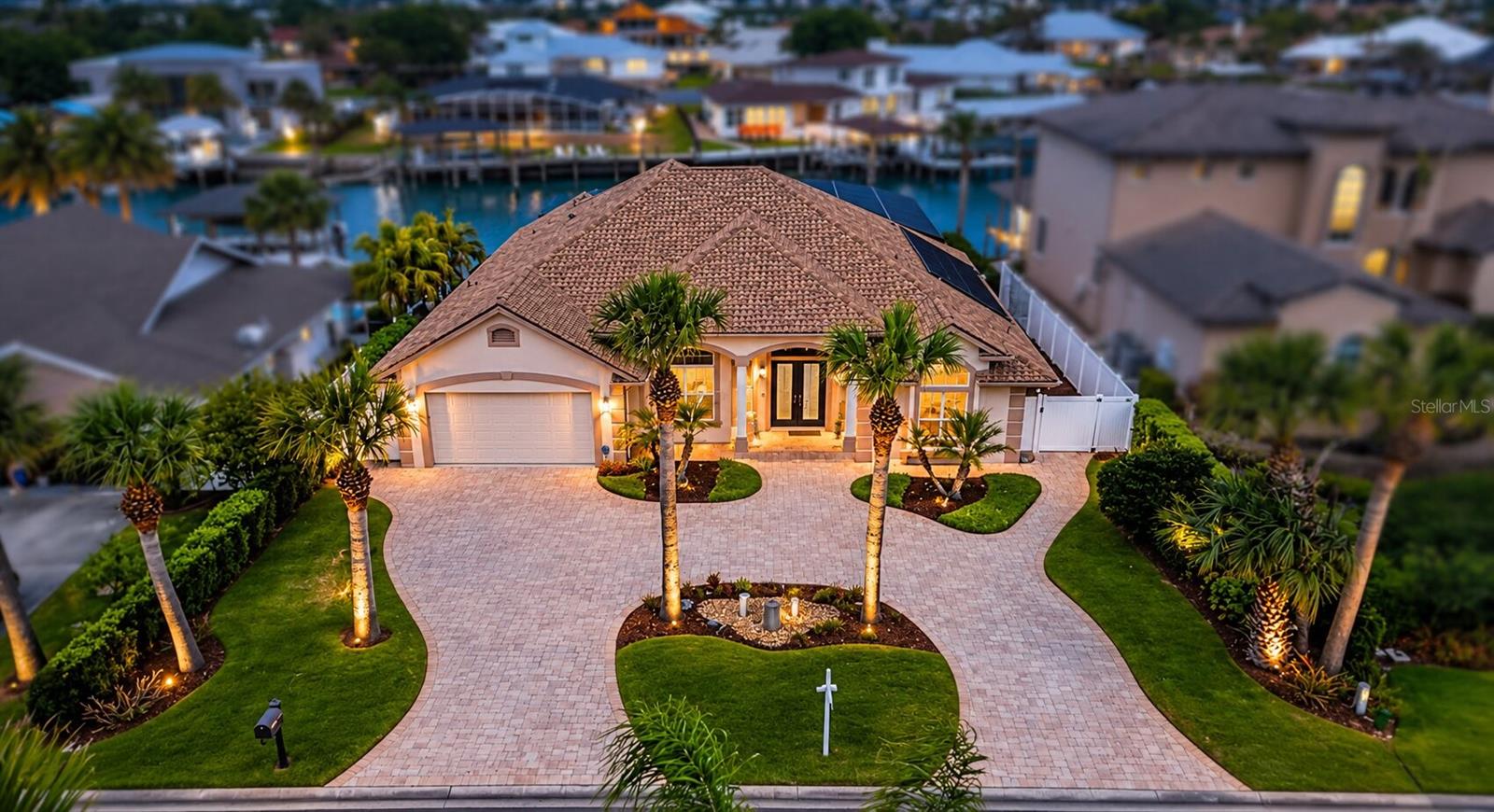 Where Architectural Elegance Meets Waterfront Luxury. Welcome to 133 Via Capri, an extraordinary coastal estate where sophisticated design, advanced technology, and resort-style living come together seamlessly. From the moment you enter through the twin glass entry doors, soaring 12-foot ceilings, custom tile inlays, curated designer lighting, and expansive walls of glass create an immediate sense of scale and refinement. The dramatic great room is filled with natural light and framed by serene views of the private pool and waterfront beyond, anchored by an 80-inch recessed Modern Flames fireplace with integrated LED lighting. The open-concept layout flows effortlessly into the German-engineered chef’s kitchen, featuring custom SieMatic cabinetry, premium Miele appliances (including steam, speed, and multifunction ovens), concealed refrigeration, induction cooktop, wine storage, quartz waterfall island, granite sink, and statement pendant lighting. The luxurious owner’s retreat offers tranquil water views, private lanai access, dual walk-in closets, and a versatile vaulted dressing or fitness space. The spa-inspired bath features frameless glass showers, rain heads, LED mirrors, and designer finishes. Guest accommodations are equally well appointed with beautifully updated baths and contemporary details.

Step outside to a true resort-style waterfront setting. The travertine lanai surrounds a heated pool and spa with sundeck, waterfall features, bubbler jets, and a fully automated iAquaLink system. Hurricane-rated electric roller shutters add convenience and peace of mind. The fully equipped summer kitchen includes granite counters, built-in grill, searing burner, beverage cooler, and bar seating for six—perfect for entertaining. For boating enthusiasts, the property offers exceptional dockage with a covered lift for boats over 25 feet, a fixed dock for yachts over 45 feet, floating dock with aluminum gangway, integrated lighting, and surveillance. With direct access to open water, this is a rare opportunity to enjoy the best of New Smyrna Beach waterfront living. 133 Via Capri is more than a home—it is a statement of lifestyle, craftsmanship, and coastal sophistication. All information recorded in the MLS is intended to be accurate but cannot be guaranteed.