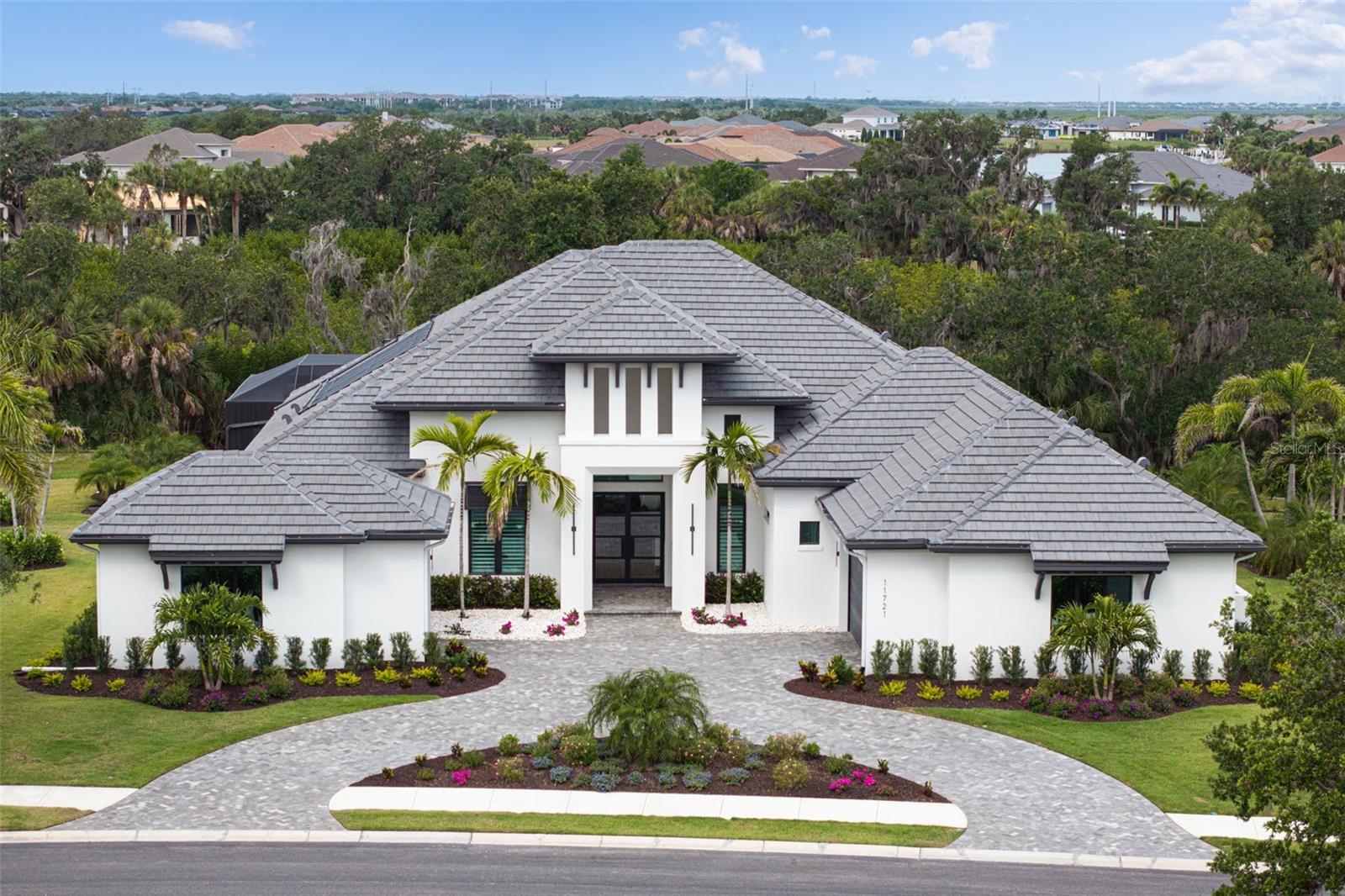 Tucked behind the gates of an exclusive waterfront community, this custom residence with a saltwater pool/spa built by renowned luxury builder Arthur Rutenberg is the epitome of refined Florida living, blending modern architecture & elevated designer finishes with exceptional craftsmanship & attention to detail throughout 4,000 square feet of living space. This move-in ready estate with 3 beds, 4 bathrooms plus a dedicated office & bonus room is perfectly positioned on over a half-acre homesite with tropical preserve views & accompanied by a deeded private boat lift in The Islands on the Manatee River! 

The architectural presence of the home is immediately evident as you enter the foyer through breathtaking 10-foot glass & iron doors. Inside, rich wood flooring flows seamlessly throughout, while custom lighting, designer finishes, elegant drapery, plantation shutters & high-end built-in features, show that every detail has been carefully considered.

The chef’s kitchen is thoughtfully designed for entertaining & everyday enjoyment. Outfitted with an elite suite of appliances including a Thermador 42-inch built-in refrigerator & dishwasher, Sharp microwave drawer, Fisher & Paykel range with 4 gas burners/4 induction burners, stainless-steel hood, the kitchen perfectly combines functionality with style. Quartz countertops, a large center island, tile backsplash, wood cabinetry with display shelving, pendant lighting, walk-in pantry with custom shelving & beverage refrigerator, create a polished & inviting atmosphere, while oversized windows frame beautiful views of the lush landscaping. 

The expansive great room & adjoining dining room serve as a stunning focal point with soaring 13-foot ceilings accented by wood beams, impressive chandeliers, gas fireplace, built-in cabinetry & oversized sliding glass doors that seamlessly connect indoor/outdoor living spaces.

Designed with lifestyle in mind, the den/office is enclosed with glass walls & enhanced by a wallpaper accents, wood columns, custom built-in cabinetry & double tray ceiling.

The spacious bonus room offers versatility for a media room or additional guest retreat. This exceptional space features custom wood accent wall, oversized windows with tropical forest views, sliding glass door access to the lanai, storage closet, & beautifully designed half bath. 

The owner’s suite serves as a luxurious private retreat with coffered ceilings, wallpaper accents, elegant chandelier, dual walk-in closets with custom cabinetry & a spa-inspired primary bathroom featuring two vanities with tile backsplashes, backlit mirrors with integrated television, tray ceiling, chandelier & oversized walk-in shower with floor-to-ceiling tile, freestanding tub & sliding glass doors that lead to a private outdoor patio with shower. 

One of the most extraordinary features is the screened outdoor living space designed to embrace the indoor-outdoor lifestyle featuring panoramic view screen, saltwater pool/spa (gas/solar heated), travertine flooring, wood plank ceilings on covered lanai, gas fireplace & outdoor kitchen with Evo gas grill, stainless-steel hood, sink, dual refrigerator drawers & cabinetry.

Other upgrades: impact-resistant windows/doors, 250-gallon propane tank, tankless hot water heater, etc. (see feature sheet). This remarkable estate embodies the best of Florida living with elegant interiors, resort-inspired outdoor spaces and private boating access to the Gulf!