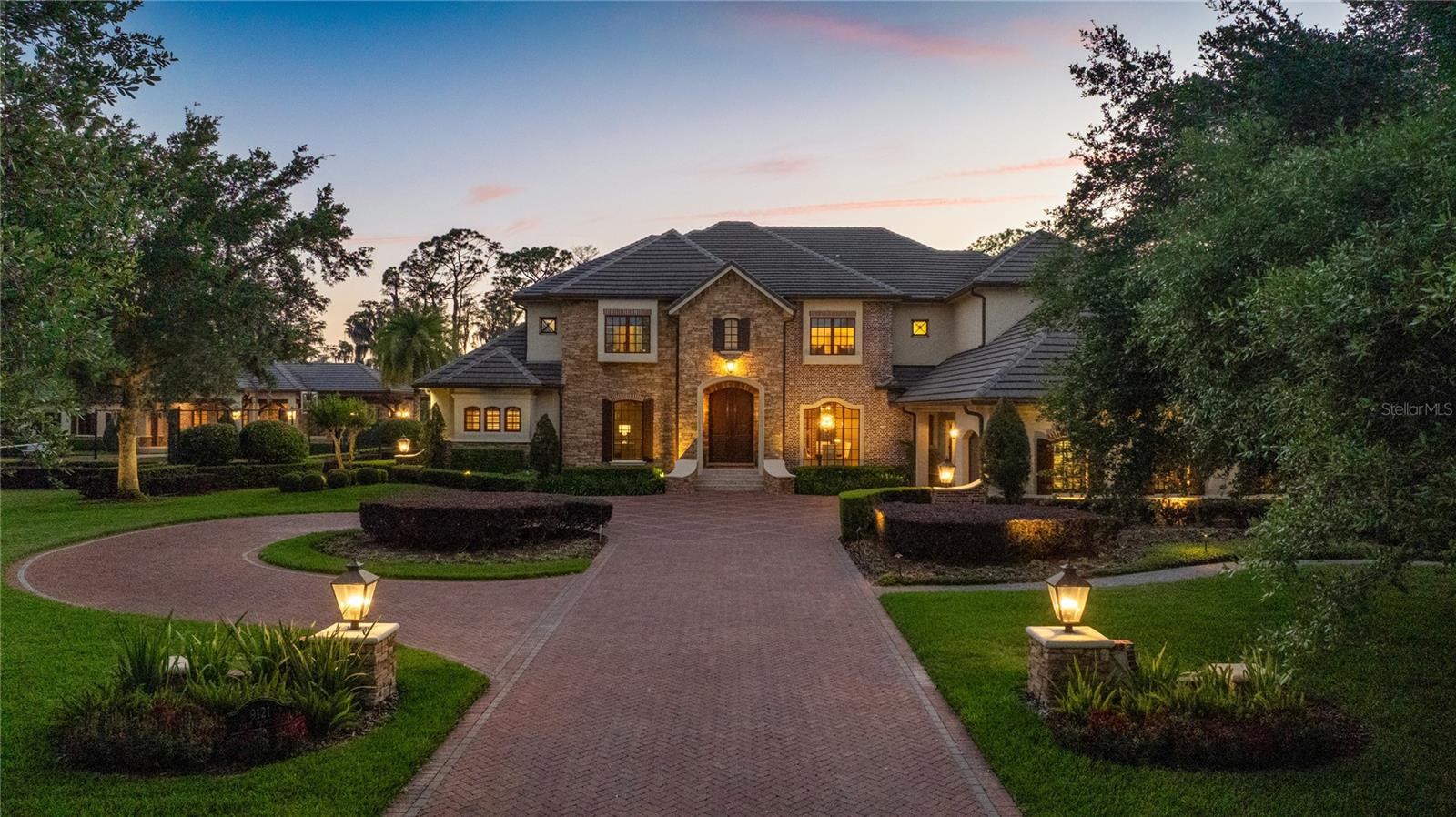 Experience the Ultimate in Luxury Living — Immerse yourself in a world of elegance, privacy, and unparalleled entertainment across four and a half acres of gated perfection within the community of Keene's Pointe on the coveted Butler Chain of Lakes in Windermere. This extraordinary estate showcases a breathtaking resort-style pool and outdoor living experience—complete with slide, waterfall, diving rock, swim-up seating, and a fireside lounge—paired with front-row views of Disney’s nightly fireworks, enjoyed from your private terrace or poolside retreat.

Designed for those who live life at the highest level, the residence is rich in craftsmanship and architectural detail, featuring all custom-designed cabinetry, wood windows, extensive molding, intricate inlays, and striking beam work throughout. A grand winding staircase sets the tone upon entry, while hand-scraped wood floors, polished travertine, and dramatic stone interior walls create a warm yet elegant ambiance. Entertain effortlessly with a circular bar and additional tasting wine bar in the game room, along with a private home theater complete with its own candy lobby for a true cinematic experience.

At the heart of the home, a professional chef’s kitchen impresses with luxury high-end appliances, custom cabinetry, a hidden pantry, dedicated coffee room, and a statement mahogany wood island. A temperature-controlled wine cellar further enhances the home’s refined lifestyle offerings.

Wellness and recreation are thoughtfully elevated with a fully equipped fitness center, private cigar lounge, lit tennis court, and a state-of-the-art indoor basketball court rivaling a professional training facility. Two interior fireplaces, two outdoor fireplaces, along with an outdoor fire pit, create inviting spaces to gather and unwind throughout the property.

Whether hosting intimate dinners under the stars, enjoying resort-style amenities, or taking in the spectacular evening skyline illuminated by Disney fireworks, every moment here feels effortless and exceptional. This is more than a home—it is a lifestyle reserved for those who demand the very best in luxury, privacy, and performance.