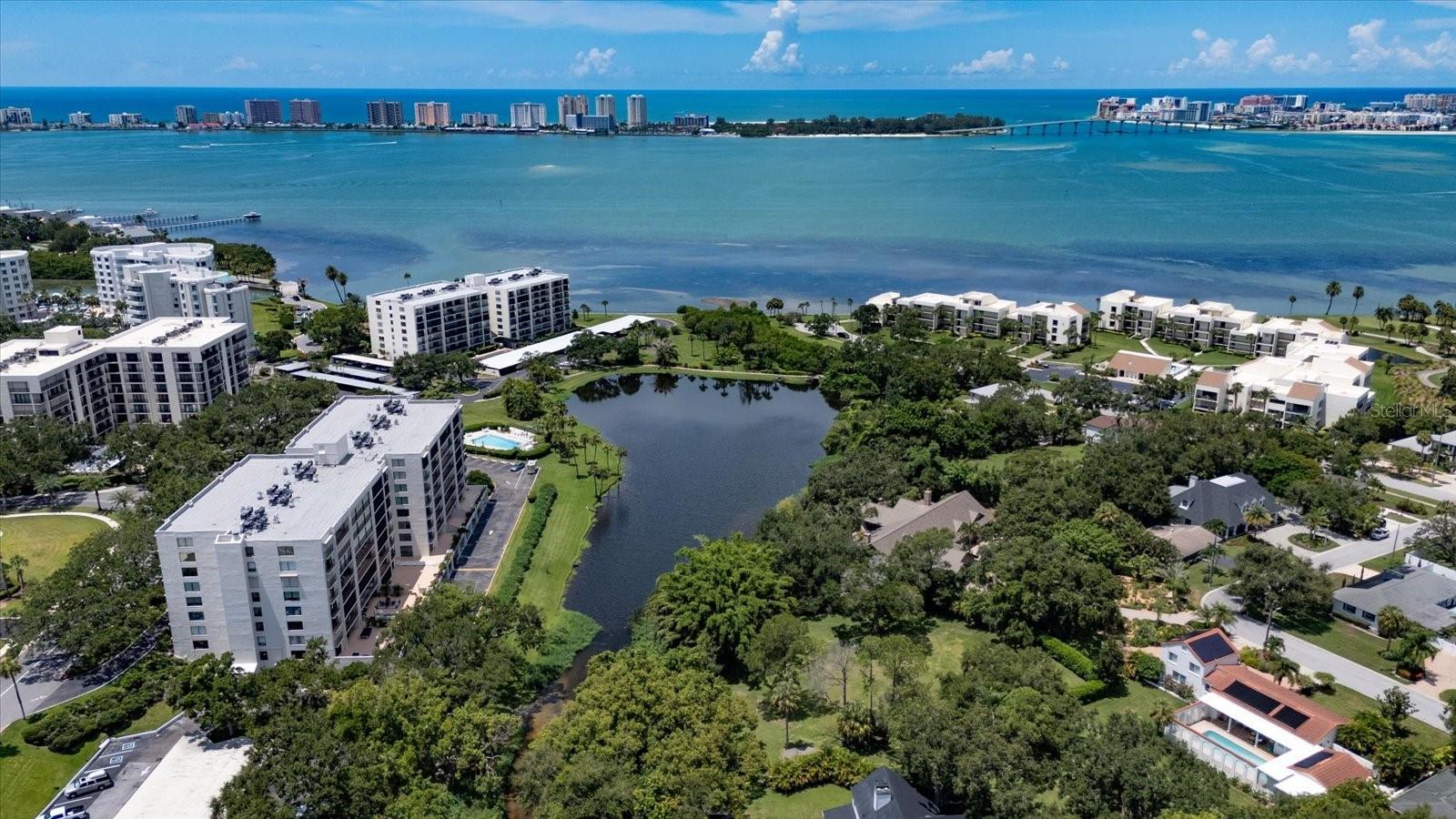 Opportunities like this don’t come along often. This rarely available Southwest corner residence in Belleview Biltmore Villas Bayshore II blends sweeping water views, timeless design, and country club perks into one complete lifestyle package. Step inside this 2-bedroom, 2-bath 4th-floor retreat offering 1,385 sq. ft. of spacious living and prepare to be captivated. The West wall windows flood the kitchen, dining, and living areas with natural light while framing panoramic vistas of the Intracoastal, Sand Key Bridge, Gulf, Lake, and the community’s resort-style pool. Your choice of two balconies—a 26-foot span across both bedrooms or a charming 12-foot Juliet balcony off the living room—ensures you’ll always have the perfect spot for sunrise coffee or sunset cocktails. The updated kitchen boasts granite countertops, mosaic tile backsplash, wood cabinetry, and a breakfast bar, all set against a backdrop of endless water views. Both bedrooms are generously sized with excellent storage, a feature that sets this residence apart from comparable units. Practical luxuries abound, too: under-building parking, a private storage room, and a heated/cooled saltwater pool that invites year-round enjoyment. Brand new water heater and microwave. Beyond your doorstep, residents enjoy the 24-hour security and manicured grounds of the world-renowned Belleair Country Club, plus preferred membership opportunities for an unmatched country club lifestyle. This is more than a condo—it’s your front-row seat to Florida’s most spectacular sunsets and a lifestyle of leisure, security, and prestige.