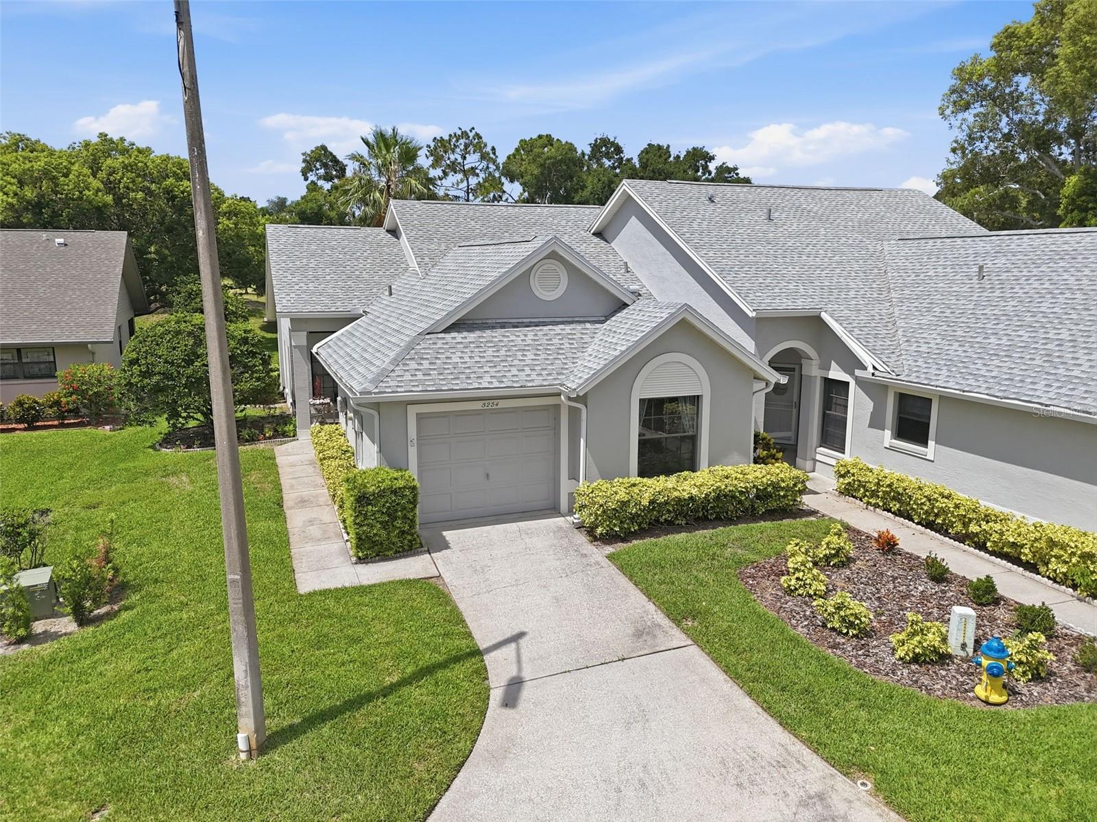 Wake up to peaceful golf course views, sip your morning coffee in the sunroom, and enjoy the carefree Florida lifestyle you've been dreaming about. Nestled within the sought-after, guard-gated Golf View Villas community, this beautifully maintained end-unit villa offers the perfect blend of comfort, privacy, and convenience.
From the moment you step inside, you'll appreciate the light-filled living spaces, soaring vaulted ceilings, and inviting open floor plan designed for both everyday living and entertaining. The spacious eat-in kitchen serves as the heart of the home, while the split-bedroom layout provides privacy for family and guests alike.
The primary suite is a relaxing retreat featuring a walk-in closet and private bath. Just beyond the living area, the enclosed rear porch becomes your own personal sanctuary—an ideal spot to watch golfers pass by, enjoy a good book, or unwind as the sun sets over the fairway.
Outside, mature landscaping and the end-unit location create an added sense of space and tranquility. The attached garage and full appliance package make moving in effortless, allowing you to start enjoying your new home from day one.
Life here extends far beyond your front door. Residents enjoy resort-style amenities including a community pool, fitness center, tennis courts, recreational facilities, and beautifully maintained grounds. Even better, the monthly association fee covers cable, internet, water, sewer, trash, exterior maintenance, pest control, and 24-hour guard-gated security, giving you more time to enjoy everything Florida has to offer.
Whether you're seeking a year-round residence, a seasonal escape, or a low-maintenance retreat where every day feels like a vacation, this charming villa delivers the lifestyle you've been waiting for.