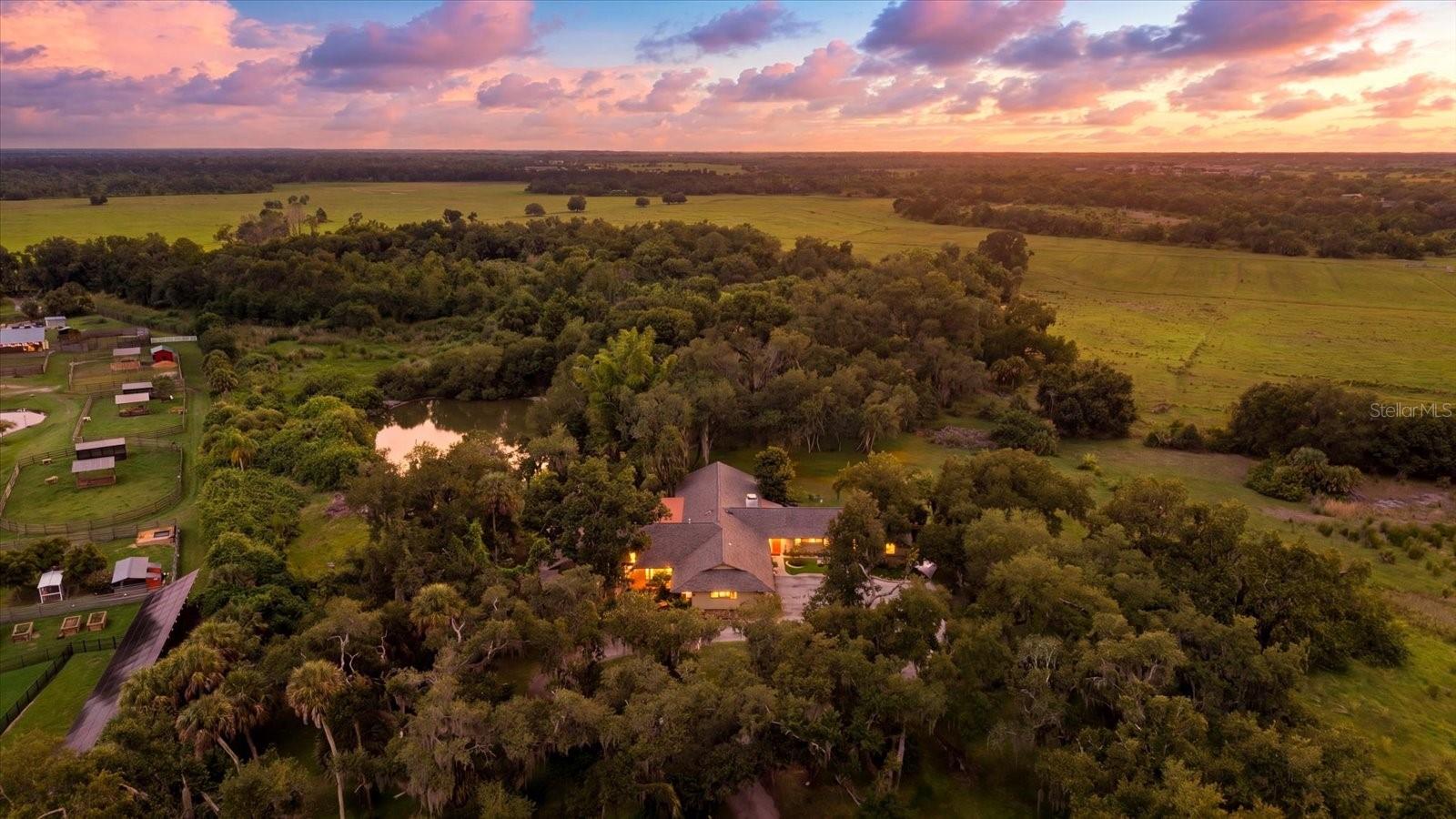 Welcome to 5850 Vanderipe Road, a spacious home set on 6.5 beautiful acres in the highly sought-after Myakka Valley Ranches community. Surrounded by gorgeous oak trees, peaceful views, and plenty of room for horses and animals, this property offers the privacy and space buyers are looking for with endless potential to make it their own. The home features 4 bedrooms, 3.5 bathrooms, 3,805 sq.ft. under air, an attached oversized 2-car garage, plus an additional detached 3-car garage and storage shed. Inside, you’ll find a generous floor plan with multiple living spaces, including a main family room with a wood-burning fireplace, an additional living room, separate dining room, and a large flex room on the north side of the home that could easily be used as a multi-generational suite, additional bedroom, office, game room, or guest retreat. The oversized primary suite offers excellent space and dual closets, while the home’s 3-zone air conditioning system provides added comfort throughout. Outdoors, enjoy tranquil Florida living from the covered and screened pool area, offering wonderful sun protection from the Florida heat while overlooking the tree-lined property, pond, dock, and peaceful sunset views. The private pond is ideal for fishing and adds to the serene country setting. Located in Unit 2 of Myakka Valley Ranches, this section has a voluntary HOA, and the community offers fiber optic internet, which is already wired to the home. Myakka Valley Ranches is known for its acreage homes, equestrian-friendly lifestyle, private roads, nature trails, and proximity to Myakka River State Park, top-rated schools, shopping, dining, and world-famous Siesta Key Beach. A rare opportunity to own a spacious home on a beautiful large-acreage property in one of Sarasota’s most desirable country communities.