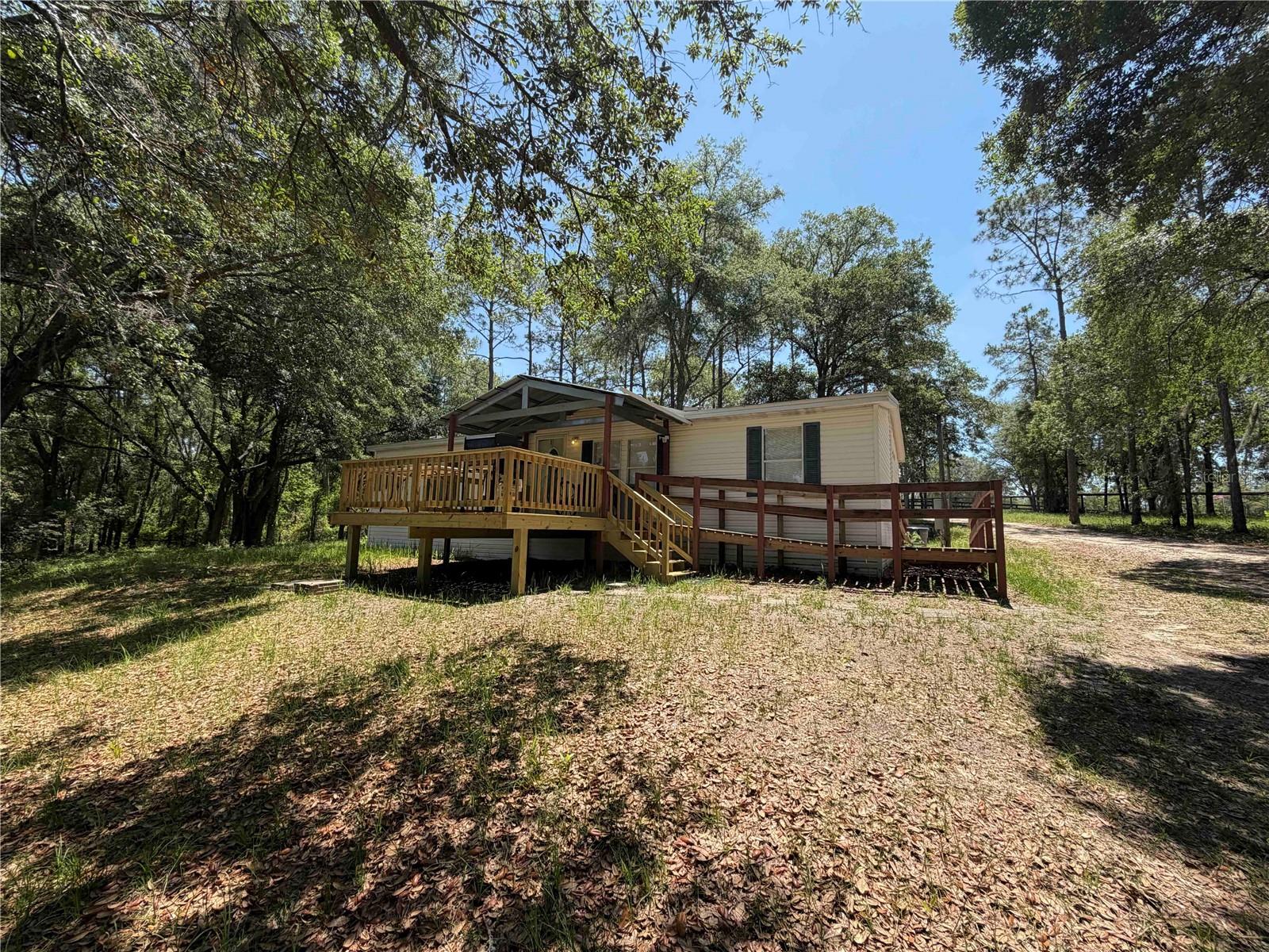 Charming 3-bedroom, 2-bath home on 5 beautiful acres in the highly sought-after Steeplechase Farms equestrian community. This well-designed 1,296-sq-ft home offers comfortable, efficient living with the perfect setup for enjoying both country life and horses right at home. The property includes one fenced pasture and four horse stalls, making it ideal for equestrians who want convenience without compromise. Step onto the porch and soak in the peaceful views of your own private acreage, where mornings are quiet and evenings are filled with nature. With direct access to the Goethe State Forest right from your backyard, you can ride straight onto miles of scenic trails—no hauling required. Steeplechase Farms is a favorite among horse enthusiasts for its location and access to premier equestrian destinations, including Black Prong Equestrian Village just 4 miles away, HITS Ocala only 15 miles away, and the World Equestrian Center just 26 miles away. Whether you compete, trail ride, or simply enjoy the equestrian lifestyle, this location puts you in the heart of it all. Conveniently situated just 40 minutes from Gainesville, 35 minutes from Ocala, 25 minutes from Dunnellon, and 15 minutes from Williston or Bronson, this property offers the perfect balance of privacy, accessibility, and equestrian living.