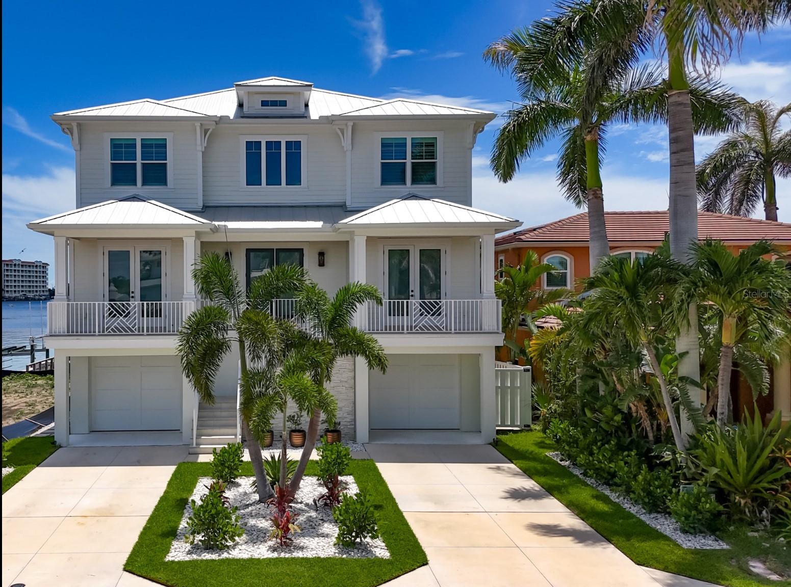 Sweeping 180 degree views of the Gulf from every room will leave you awestruck in this exquisite 2022 custom, waterfront estate. Part Hamptons, part Palm Beach and located in the small, quiet beach town of Redington Shores, this five bedroom, four bath, and four car garage has all of the modern amenities while still exuding warm, family charm. All living levels can be accessed by elevator from the garage or through the entry leading to the staircase with gleaming cable railings. Upon entry,  the soaring, light filled gallery gives a feeling of grandeur as if coming to your favorite resort. White oak flooring throughout the home continues a modern, yet warm aesthetic. Two bedrooms and two full bathrooms flank the entry, both with East facing sunrise balconies overlooking the Intracoastal Waterway. The living room, kitchen and dining are overlooking the water where expansive views West to the beach are unmatched in any waterfront home. In the kitchen, Cafe appliances blend into the design with a stunning natural gas range, high end plumbing and a fridge and freezer large enough to accommodate the largest of families. The pantry with wine fridge, floor to ceiling storage and a washer/dryer tucked out of sight is the perfect addition to this entertaining space. Sliding doors that pocket out of view, open the living room to the patio, further immersing the space with a breezy water overlook. Hurricane shutters allow you to close off the balcony when you are away making it a perfect second home. Tear yourself away if you must and head upstairs to the gulfside primary retreat. If lazy mornings sipping coffee, perched over the water is your vacation plan then this is your new respite. The primary bathroom exudes elegance with marble and wood tile flooring, a soaking tub, separate toilet room and double vanity with plentiful storage. Double french doors to the walk in closet that you will find only in new construction, will have you saying C’est Magnifique at the options for storage and clothing. One bedroom with ensuite bathroom and a bedroom currently used as an office complete the third floor. Electric blinds, a central vacuum, audio speakers and a water softener are a few of the indoor conveniences. Outdoors on the ground level you have room for a pool and plenty of garage space for all the pool and boating equipment. Right off of the dock is a prime tubing, paddle boarding and waterskiing cove. Or drop a line right off the dock for some fishing fun. The 13,000 pound boat lift and dock will house your boat to get out to the Gulf via John’s Pass or Clearwater Pass for some of the finest fishing and blue water adventures in the area. The Redingtons are known for their residential appeal with very few commercial interests and a community feel. The beach is walking distance and has many public access points and parks with playgrounds to enjoy. New construction coupled with serene views and elegant and timeless design is yours.  The seawall was buit in anticipation of a waterfront pool being added.  The renderings show the owners preferred design for a pool but you can modify and build to your taste.
