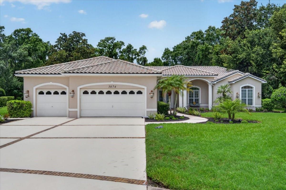 Custom-built and beautifully maintained, this stunning four-bedroom plus office, four-bath, three-car garage, pool home is set on 3.3 acres with peaceful conservation views and no rear neighbors in the Regency section of Crescent Oaks. A stately covered front porch with columns and leaded-glass double doors opens to a home that immediately feels grand, bright, and inviting, with soaring ceilings, rich Brazilian cherry wood floors, elegant architecture and tasteful finishes. Windows and French doors in the living room frame the pool, lanai and preserve, extending the sense of openness and connection to the outdoors. Decorative columns and a tray ceiling define the formal dining room while keeping it open to the living room. Conveniently positioned just beyond the dining room, the spacious, well-equipped kitchen opens to the breakfast nook and family room, creating an easy flow for everyday living and entertaining. Abundant oak cabinetry, granite countertops, stainless steel appliances, a gas range, wine storage and an elevated breakfast bar provide ample function and seating. A mitered-glass corner window brings pool and preserve views into the breakfast nook, while the impressive family room draws in the surrounding scenery through a striking arrangement of arched windows and multiple sets of French doors. Rich cherry wood floors and a gas fireplace bring warmth to this bright, open gathering space. The primary bedroom retreat is set apart within the split-bedroom plan and features a transom window and French doors to the lanai and views beyond. Two walk-in closets with built-in organizers provide generous storage, while the ensuite bath offers extensive marble finishes, soaking tub, an oversized shower with a curved glass-block wall, double-sink vanity, and a separate water closet with bidet. On the opposite side of the home, two bedrooms share a Jack-and-Jill bath with a double-sink vanity, while the fourth bedroom includes its own ensuite bath and walk-in closet. A separate full pool bath provides direct lanai access and includes a glass-enclosed shower. Near the front entry, the dedicated office features plantation shutters, built-in cabinetry and ample workspaces. Outside, the home fully embraces its remarkable setting. The oversized screened pool and lanai create an exceptional outdoor living space with covered seating and dining areas, an outdoor kitchenette with a stainless gas grill, and a sparkling pool paired with an elevated heated spa and cascading tiered waterfall. Beyond the enclosure, the expansive backyard stretches toward the preserve, providing a peaceful natural backdrop for entertaining, unwinding and enjoying the Florida lifestyle. Additional features include a tile roof (2020), updated bathrooms, two Carrier air-conditioning units, newer cherry wood flooring, a resurfaced pool (2018), newer pool screens, epoxy garage floors (2021), central vacuum, digital alarm system, water softener, irrigation well and a three-car garage with room for multiple vehicles, a golf cart or recreational items. Crescent Oaks offers a 24-hour guard gate and optional memberships for championship golf, tennis, dining and country club amenities. The home is conveniently located near schools, the YMCA, shopping, restaurants, Tampa International Airport, Gulf beaches and the Pinellas Trail, with a low HOA and Flood Zone X designation. Schedule your private tour today!