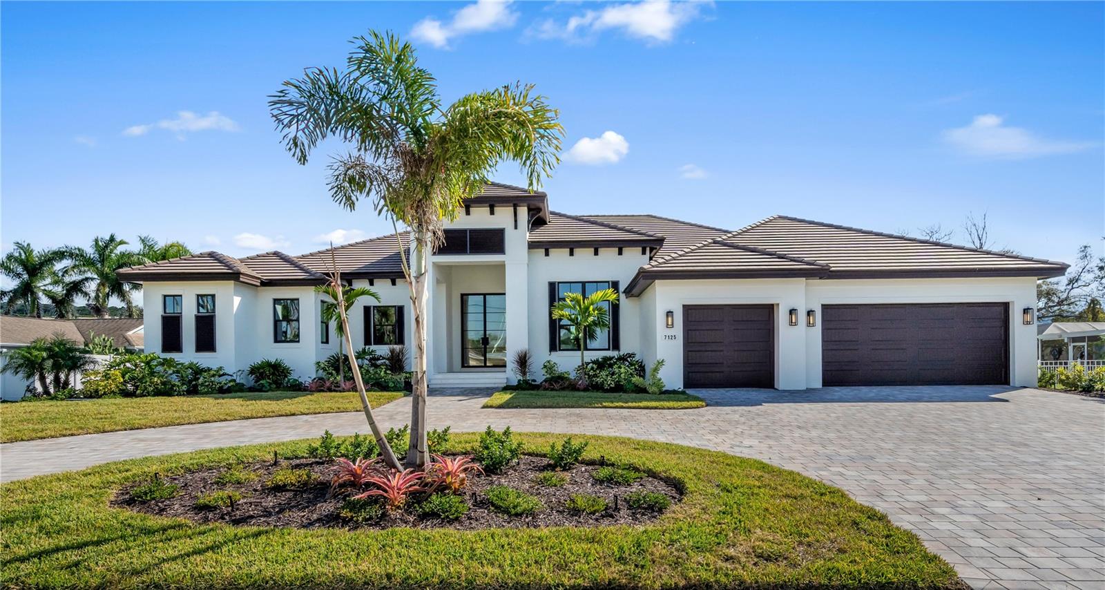 One or more photo(s) has been virtually staged. The Abaco Model is a stunning Sarasota luxury residence offering 4,343 square feet of refined living space and 6,273 square feet under roof, featuring four true bedrooms and six total rooms. This home is Florida Green Home Bronze Certified, reflecting thoughtful construction, energy efficiency, and sustainable building practices.

Upon arrival through dramatic 10-foot iron front doors, the foyer provides a breathtaking sightline through the home to the pool and canal beyond. The oversized great room is ideal for entertaining and showcases stained cypress beams, a gas fireplace with full-height tile surround, and a 16-foot-wide by 10-foot-high pocketing sliding glass door that opens seamlessly to the outdoor living and pool area.

The chef’s kitchen features an oversized island with gas cooktop, walk-in pantry, and sunlit windows above the sink for abundant natural light. The private owner’s wing includes a refined library or office adjacent to the owner’s suite, both enjoying water views. Dual oversized customized built in walk-in closets and a spa-inspired owner’s bath complete the retreat with a freestanding soaking tub, walk-in shower, private water closet, and separate his-and-her vanities.

Two additional guest suites accommodate king-sized beds and feature ensuite baths and walk-in closets. A waterfront bonus room at the rear of the home also enjoys water views and is serviced by a nearby full bath that also functions as a powder bath and pool bath. Two additional flexible sleeping rooms bring the total sleeping capacity to six.

The expansive outdoor living and dining area overlooks the pool and spa and includes a cozy gas fireplace, creating the perfect waterfront entertaining setting. The three-car garage leads into a walk-in laundry room with a dedicated storage closet.

All windows and exterior doors feature Low-E impact glass, all interior doors are 8-foot shaker style, all interior walls include sound batt insulation, walls and ceilings have smooth finishes, and all interior floors are tiled throughout. Cabinetry is by Wood-Mode/Brookhaven.

The West Indies–inspired exterior elevation features shutters, corbels, decorative brackets, and a concrete tile roof. The private dock includes a high-capacity 33,000-pound boat lift with water and power and is capable of accommodating 40–50-foot vessels with protected deep-water access and quick entry to Sarasota Bay making this property ideal for the serious boater.