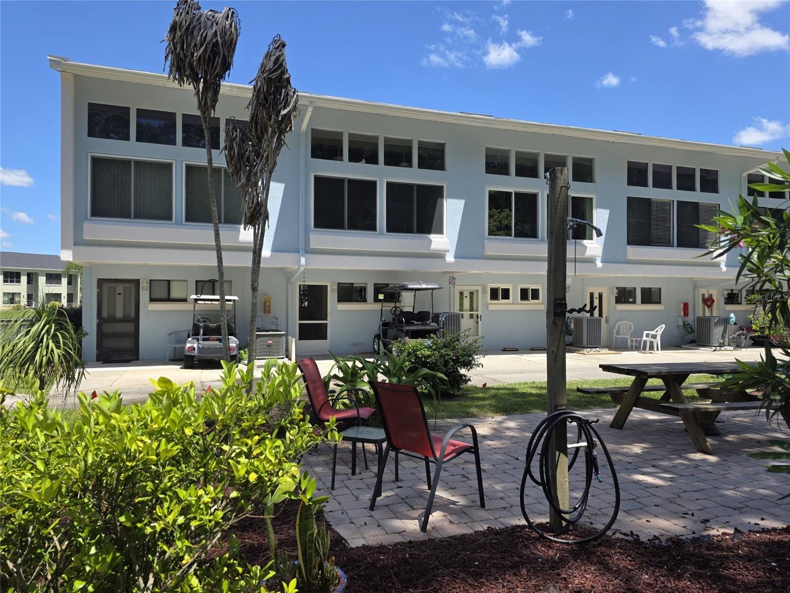 Owner financing available for this beautiful 2-bed/2-bath Islands condo located in the gated clothing-optional community of Paradise Lakes. This townhouse-style home has wood laminate throughout and stunning water views from the kitchen, primary bedroom, living/dining rooms, and screened deck. The kitchen has tons of cabinet storage, smooth-top range, built-in microwave, dishwasher, stainless steel refrigerator, solid granite counters, rolling island, and upper/lower side cupboard. Full downstairs bath has a granite-top vanity and shower. Main upstairs bath has dual sink granite-top vanity, linen storage, garden tub/shower, and skylight. Light and bright primary bedroom has water views and walk-in closet. The second bedroom has a built-in closet and window overlook to kitchen - perfect for guests or home office. Living/dining room is ideal for entertaining with built-in wet bar, mini-fridge, and upper/lower cabinets. Enjoy outdoor living from the screened rear deck with expansive water views. Other features include a new AC system in 2025, dual-pane windows, water softener, and attic fan. Existing furnishings, appliances, and decor included. Park your golf cart right outside the door! Buyer is responsible for verifying all information, details and dimensions. Condo association approval of Buyer is required including application, fee, background check, orientation, and membership in a recognized nudist organization. Optional membership to Paradise Lakes Resort is not included in monthly condo association fee.