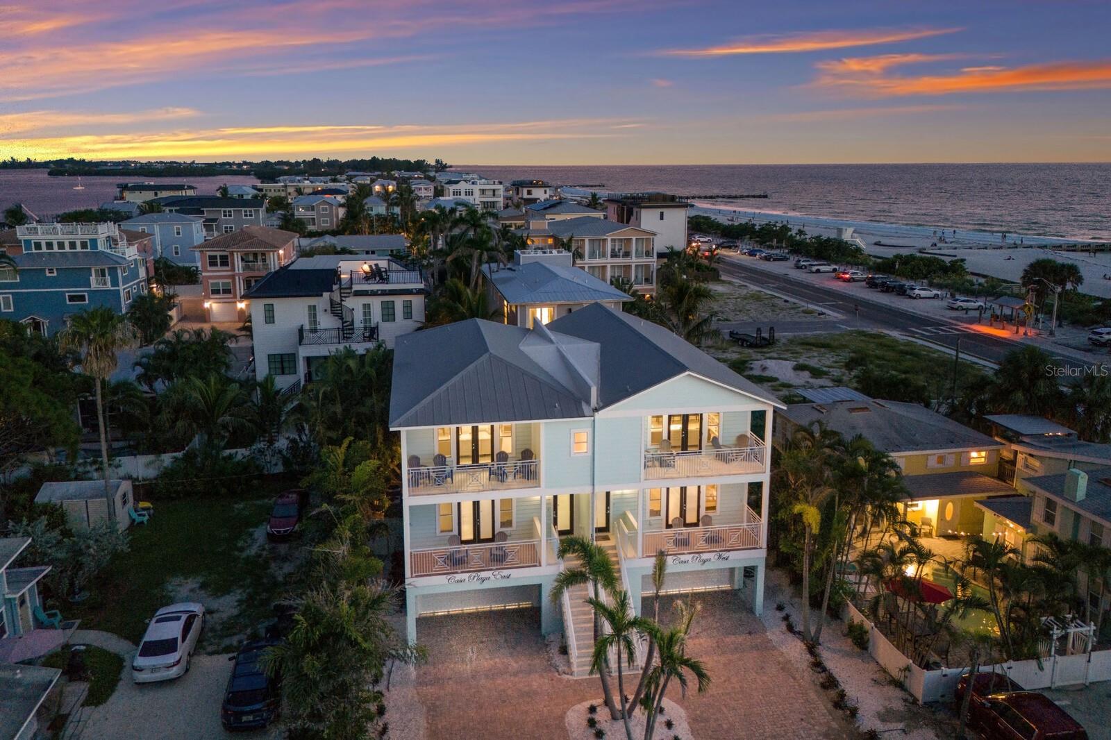 Offering the full duplex, this property presents a rare opportunity to own two residences, each featuring 4 bedrooms and 3.5 bathrooms, for a combined total of 8 bedrooms and 7 bathrooms.
Each side showcases an expansive open floor plan with vaulted ceilings and beam detailing, creating inviting living spaces designed for gathering and entertaining. Spacious living areas connect to multiple covered decks that capture Gulf-to-Bay views.
Both kitchens include solid wood cabinetry and granite countertops, while the primary and guest bedrooms offer en-suite bathrooms and walk-in closets for comfort and privacy.
The outdoor setting centers around a private pool area with covered spaces for dining and relaxation, highlighted by a waterfall feature.
Elevators in each residence provide access to all levels.
Located in an area that allows for daily or weekly rentals, this offering provides flexibility for personal use or income potential, all just steps from the Gulf of Mexico and close to the bay, Bridge Street, trolley access, dining, and boutique shopping.