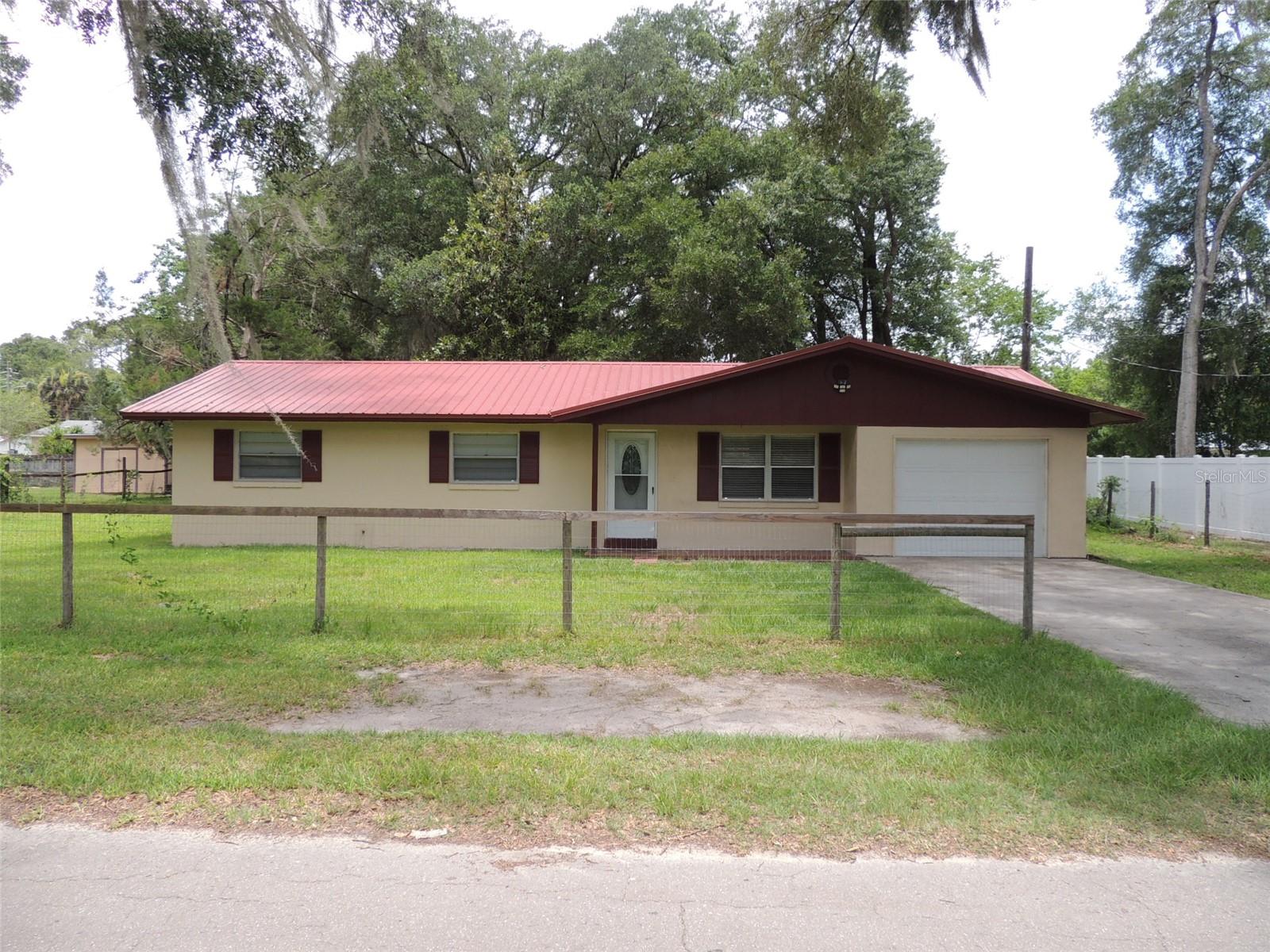 MOVE-IN READY CONCRETE BLOCK/STUCCO HOUSE IN TOWN!! This 3 bedroom, 1-1/2 bath concrete block home has been updated with new kitchen cabinets, new appliances, pantry, updated bathrooms, ceramic tile floors, upgraded electric, newer metal roof and newer A/C. Attached garage and sits on two city lots with a large back yard. City utilities and a short walk to the Post Office, Grocery Stores, Churches and Drug Stores. Just a short, scenic drive from both Gainesville and Ocala, this property makes it convenient to experience a variety of shopping, dining, medical, and event options.