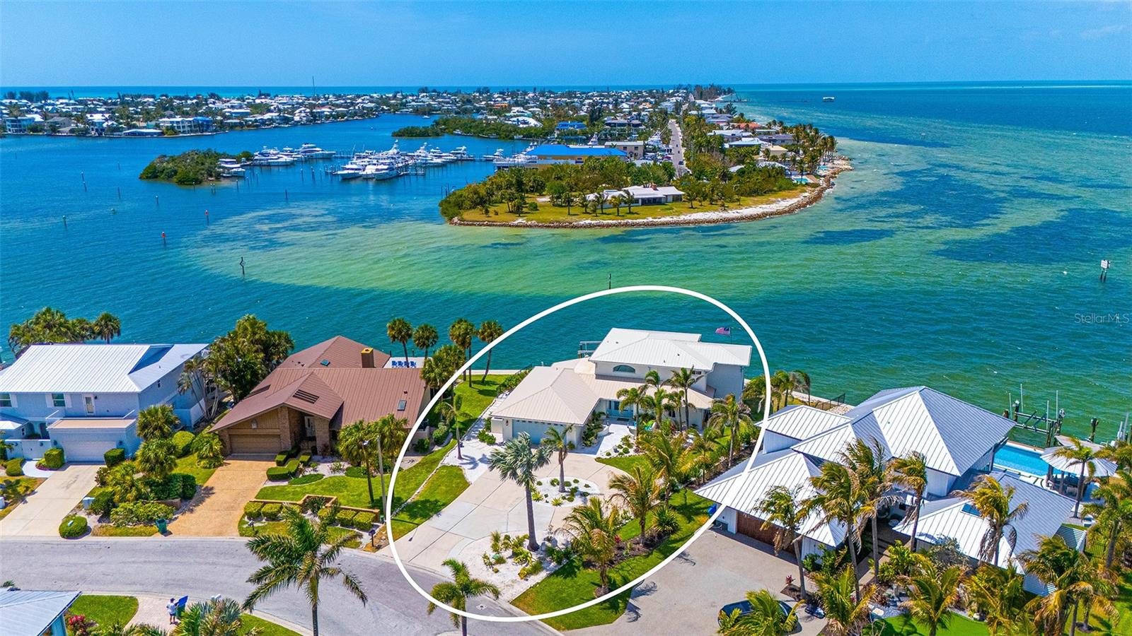 Set within the desirable North Point Harbour enclave of Key Royale in Holmes Beach, this impeccably reimagined waterfront residence captures the essence of coastal living, where clean architectural lines, curated interiors, and uninterrupted water vistas converge. From the moment you enter, every space is thoughtfully oriented to frame expansive views of Bimini Bay and Tampa Bay, creating a dynamic yet tranquil backdrop that evolves throughout the day, from soft morning reflections to vivid Gulf Coast sunsets. Updates include hurricane windows and sliding glass doors, new roof, wood look tile throughout, new composite dock and 20,000# lift. The floor plan is thoughtfully designed to balance privacy with hospitality, anchored by two primary suites, offering exceptional flexibility for hosting guests or extended stays. The main-level suite provides convenience and accessibility, while the upper-level primary and additional bedrooms create a quiet retreat with elevated water views. At the heart of the home, a statement kitchen serves as both a culinary showpiece and social hub. Outfitted with a Monogram refrigerator and gas range, the space is complemented by an expansive Cambria quartz island with seating for six. Two wine refrigerators are thoughtfully integrated, elevating the entertaining experience and seamlessly connecting to the dining and living areas. Beyond the interiors, the home extends into an exceptional waterfront lifestyle. A newly constructed dock with a 20,000-pound lift caters to serious boating enthusiasts, while the property offers ample space to design a custom poolscape tailored to your vision. The oversized two-car garage offers generous additional storage, ideal for a golf cart, beach essentials, bicycles, and coastal lifestyle gear. Directly across the street, residents enjoy convenient access to North Point Harbour's heated pool, as well as a tennis and pickleball court adding an additional layer of resort-style living just steps from your front door. Residents enjoy the close proximity to the sugar-white sand beaches of Anna Maria Island, the restaurants, art galleries and shops in Holmes Beach. Other nearby amenities include dog park, public tennis/pickleball courts, basketball, skate park, library and soccer fields. Ideally positioned just moments from the fairways of Key Royale Golf Club’s private par-32, nine-hole course, optional membership provides access to golf, dining, and a vibrant social scene. Downtown Bradenton, Sarasota, SRQ Airport, Tampa Airport and St. Pete/Clearwater Airports are all within an hour drive away. Residents and visitors appreciate all the opportunities to enjoy the theatre, art fairs, farmers markets, concerts, boating, fishing and shopping that is convenient for the Florida lifestyle. This is more than a home. It is a lifestyle of relaxed coastal luxury, effortless entertaining, and a constant connection to the water on Anna Maria Island. BEAUTIFUL FURNISHINGS OF THIS HOME ARE NEGOTIABLE.