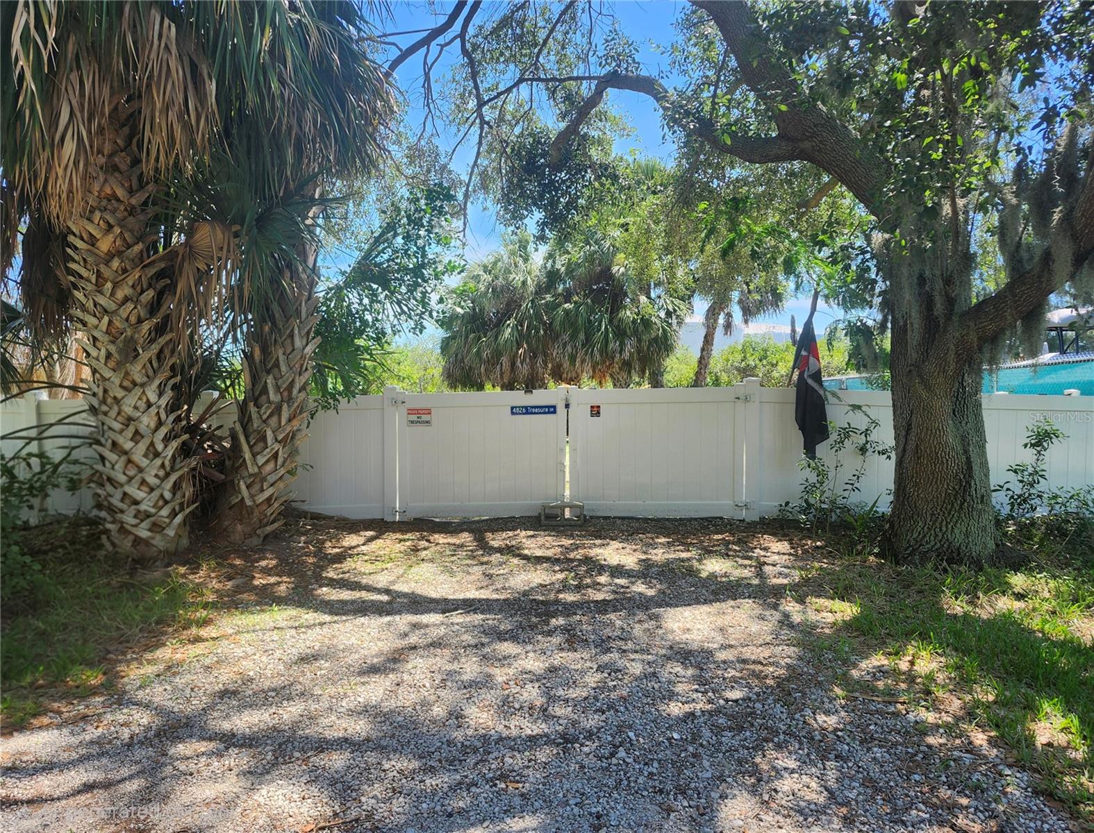 Rare Waterfront Lot on a Private Island Retreat! Just two minutes from Hwy 19 with convenient access, this exceptional homesite is tucked away on a quiet dead-end street, offering the perfect balance of privacy, tranquility, and coastal charm. Positioned to capture breathtaking western sunsets, the rear of the property overlooks Cross Bayou — a saltwater canal with direct Gulf of Mexico access, ideal for boating, fishing, kayaking, and birdwatching. Surrounded by natural beauty and abundant wildlife, the property features a fresh white vinyl fence, double gate entry, and a substantial gravel pad, making it ready for immediate enjoyment or future development. With only a handful of neighboring properties, the peaceful setting creates the feeling of a secluded island escape while still being just minutes from the restaurants, shops, and conveniences of downtown New Port Richey. Enjoy paved roads leading to your private waterfront retreat where every evening ends with spectacular sunset views and the relaxing atmosphere of true Florida coastal living. This is a rare opportunity to own your own slice of paradise along the Gulf Coast.