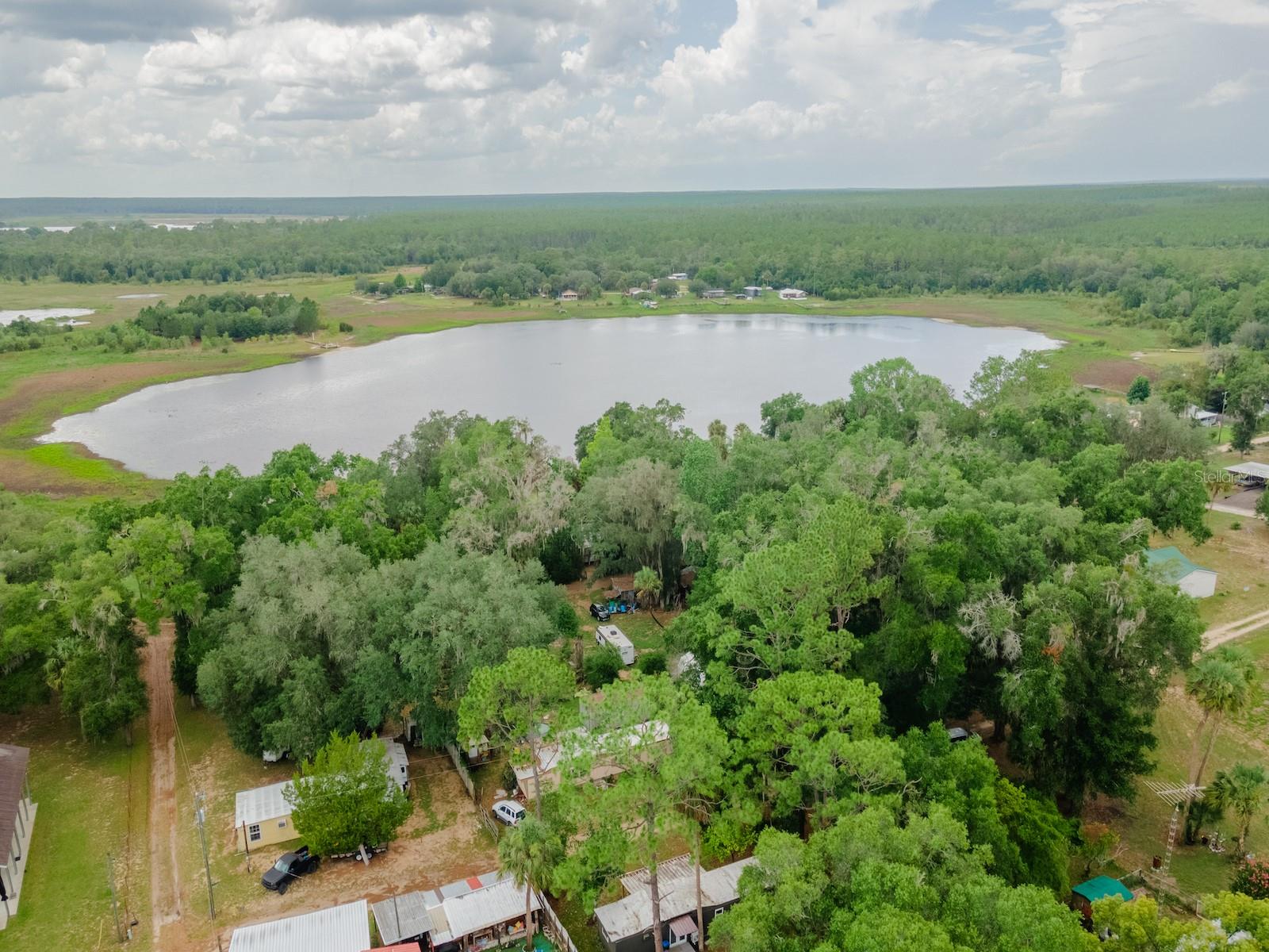 Charming Updated Retreat in Buck Skin Manor

18811 NE 248 Terrace, Salt Springs, FL 32134
2 Bedrooms | 1 Bathroom | 720 Sq Ft | Furnished | Move-In Ready

Nestled in the peaceful Buck Skin Manor subdivision with .29 acre double lot in the heart of the Ocala National Forest, this beautifully updated home offers the perfect blend of comfort, affordability, and outdoor adventure. Located just north of Salt Springs, you'll enjoy a quiet forest setting with an easy commute to Palatka for shopping, dining, and everyday conveniences.

Originally built in 1970, this single-wide mobile home has undergone extensive renovations and is ready for its new owners. With 2 bedrooms, 1 bathroom, office/playroom and 720 square feet of living space, the home feels bright, welcoming, and surprisingly spacious.

The inviting living room features an electric fireplace, abundant natural light, and French doors leading to the rear deck, creating the perfect place to relax after a day of exploring the outdoors. The open-concept design flows seamlessly into the updated kitchen, which boasts a large center island, newer cabinetry, updated countertops, and newer appliances—all included with the sale.

The bedrooms are comfortable and cozy, while the completely remodeled bathroom features a tiled shower surround, glass door enclosure, updated vanity, new toilet, and modern flooring. Additional improvements completed by the seller include updated laminate flooring throughout, fresh interior and exterior paint, new windows/doors, upgraded PEX plumbing, 18k BTU Mini split HVAC and more.

Even better, the home is being sold fully furnished, making it an ideal full-time residence, seasonal getaway, or rental investment. The roof has received a fresh protective coating and is ready for Florida's rainy seasons ahead.

Outside, you'll find a covered storage area perfect for equipment and tools, along with a zero-turn mower included in the sale. The yard features mature landscaping and fruit trees, including pink grapefruit, yellow grapefruit, and tangerine trees, providing fresh fruit right from your own backyard.

The property is serviced by Marion County Utilities water, with a private well also located on-site.

Outdoor enthusiasts will appreciate being just minutes from the Ocklawaha River, Salt Springs, Silver Glen Springs, Juniper Springs, and countless trails throughout the Ocala National Forest. Whether your passion is fishing, hunting, kayaking, hiking, horseback riding, or off-road adventures, you'll find endless opportunities nearby.

Conveniently located only minutes from Salt Springs and a short drive to Palatka, you'll enjoy easy access to grocery stores, restaurants, hardware stores, gas stations, Walmart, Lowe's, and much more.

This is a rare opportunity to own an affordable, fully updated, move-in-ready home in one of Florida's most scenic outdoor recreation areas.

Schedule your private showing today and discover the charm of Buck Skin Manor living!