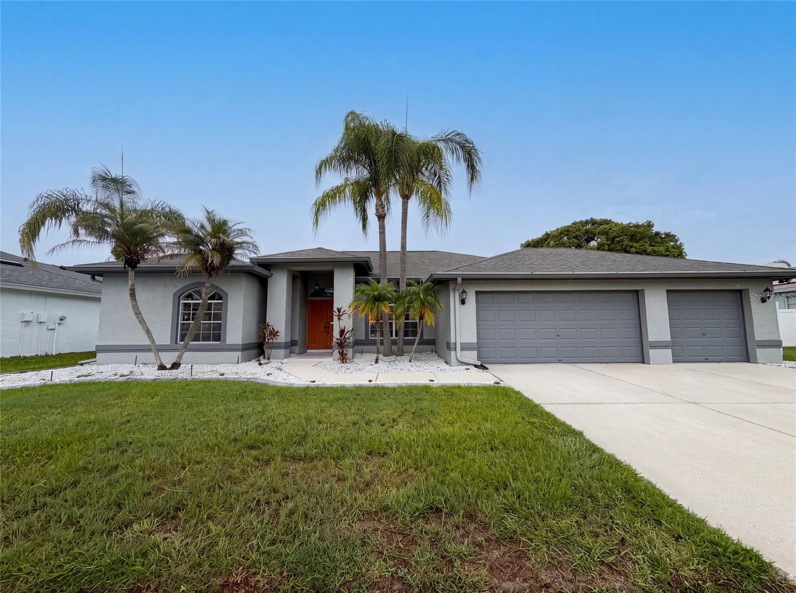 Virtually Staged. 12919 Prestwick Dr is a one-story Riverview home with a landscaped front yard and palm trees. The kitchen has white shaker cabinetry, quartz countertops, stainless steel appliances, and a center island with seating that opens to the tiled living and dining areas. The primary bedroom connects to a bathroom with a dual-sink vanity, a soaking tub, and a separate shower, while additional bedrooms provide neutral wood-look flooring and natural light. A screened lanai runs along the rear of the home and overlooks a fenced backyard for outdoor use. An attached garage completes this well-maintained residence with practical amenities throughout every room.. Included 100-Day Home Warranty with buyer activation
