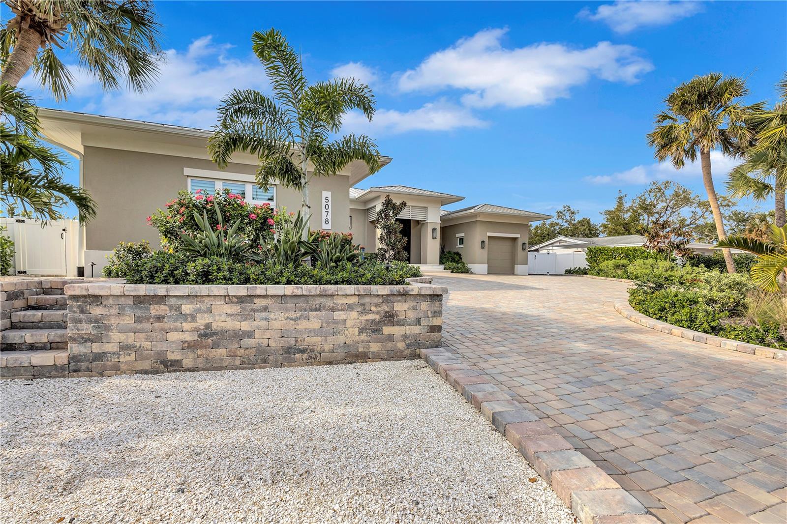 Completed in 2024, this custom one-story canal-front residence in the sought-after Sara Sands neighborhood offers a seamless blend of modern coastal design and effortless island living. Ideally located just minutes from Siesta Key Village, you’re close to boutique shopping, top restaurants, coffee shops, popular wine bar, and lively evening entertainment—while enjoying excellent boating water with quick 10–15 minute access to the Intracoastal Waterway.

The home welcomes you with striking curb appeal, featuring a wide paver driveway, lush tropical landscaping, and a covered entry leading to an impressive wood front door. Inside, the open, airy floor plan is designed to maximize indoor-outdoor living. The main living space flows beautifully into the outdoors, highlighted by a dramatic covered lanai with a rich wood-plank ceiling, recessed lighting, and modern ceiling fans—creating a resort-style atmosphere year-round.

The gourmet chef’s kitchen is both functional and elegant, showcasing custom wood cabinetry, quartz countertops, premium appliances, and a dedicated beverage bar ideal for entertaining. Large sliding glass doors open fully to the expansive covered patio, creating a true extension of the living space.

This thoughtfully designed home offers four bedrooms and four bathrooms, providing privacy and comfort for family and guests alike. Each space is finished with clean lines, high ceilings, and quality craftsmanship throughout.

Outdoors is where this property truly shines. The large covered patio deck includes multiple seating and dining areas, a fully equipped outdoor kitchen, and overlooks a resort-style pool with sun shelf, all framed by tropical landscaping and tranquil canal views. A covered boathouse with 10,000 lb lift, charming gazebo, and fenced yard complete this exceptional waterfront setting—perfect for boating days, sunset gatherings, and relaxed island evenings.

This is a rare opportunity to own a nearly new canal-front home in one of Siesta Key’s most desirable neighborhoods—offering luxury, lifestyle, and location in perfect harmony.