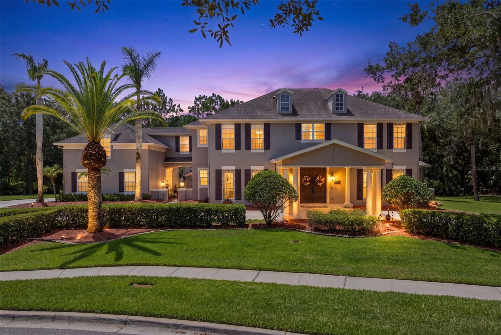 Rare opportunity to own the largest homesite in all of Avalon Park, backed by almost $98k in documented upgrades! Situated on an expansive .75 acre double lot, bordering Live Oak Park & walking trails w/ private conservation, a level of privacy rarely found. A huge semicircular driveway, extended side driveway, double front doors & front portico for add'l covered parking & an EV charger in the 3 car garage for convenience. The main home features 5 bedrooms, 4.5 baths. The detached garage apartment adds a 6th bedroom & full bath, bringing the total to 6 bedrooms & 5.5 baths, making it ideal for multi-generational living. Traditional solid oak flooring throughout the main home, aside from 2 downstairs bedrooms. The laundry room includes a sink, washer & dryer. A formal living room features a gas fireplace, & the great room is anchored by a 72 inch windmill ceiling fan, wet bar & a home theater system w/ surround sound that stays w/ the home, plus a 2nd wired theater setup in the study near the pool bath. A whole home smart automation hub w/ smart outlets & automatic lighting controls installed for remote controlled holiday lighting, plus a central vacuum system throughout. Dual home security systems allow the garage apartment to operate independently, w/ smoke & CO2 detectors. The kitchen offers rich beautiful wood cabinetry, quartz counters, stainless appliances, w/ a subway tile backsplash, sitting area & breakfast bar seating. Upstairs, the primary suite includes 2 oversized walk in closets & French doors to a private balcony overlooking the pool, an en suite w/ a jetted tub, travertine finishes & a frameless shower, plus a dedicated office w/ 2 work station setups & ample cabinet space. The guest ensuite & upstairs hall bath have both been updated w/ new fixtures, frameless showers and/or cabinets. A fully renovated 1 bedroom apartment above the garage offers its own private covered entrance & full kitchen, w/ new luxury vinyl flooring, quartz counters & stainless steel appliances. The living room & bedroom feature hardwood flooring & crown molding. The entry closet has been upgraded w/ a water hookup for a washer & dryer (not included), a new water heater & the apartment has its own central vacuum. The oversized screened pool area was resurfaced w/ a pebble tec finish & retiled, extensive rock waterfalls w/ an auto timer, salt system, remote pool automation system controlling the pool light, 3 waterfalls, a spill over feature & the pool cleaner. French doors lead out to the screened lanai & full pool bath, plus an outdoor kitchen w/ a grill & sink, all surrounded by mature woods. A detached playhouse offers its own air conditioning, a cozy loft & a screened back porch. Both main house A/C units are new & run on smart thermostats, the garage doors are insulated & reduce garage temp by about 20 degrees, additional attic insulation & solar attic fans keep the attic cooler, & a solar hot water system adds even more efficiency. Avalon features a splash pad, community pools, gated playground w/ bathrooms, jogging/biking trails, dog park & football/soccer/baseball fields, sand volleyball, basketball/tennis/pickleball/racquetball courts. Zoned for top-rated schools. Downtown Avalon provides shops, restaurants & professional services. Near Downtown Orlando, 528, 417 & 408, Waterford Lakes, UCF, Medical City, Lake Nona, Florida's beaches & major attractions. Basic cable & internet included in HOA dues via Spectrum.