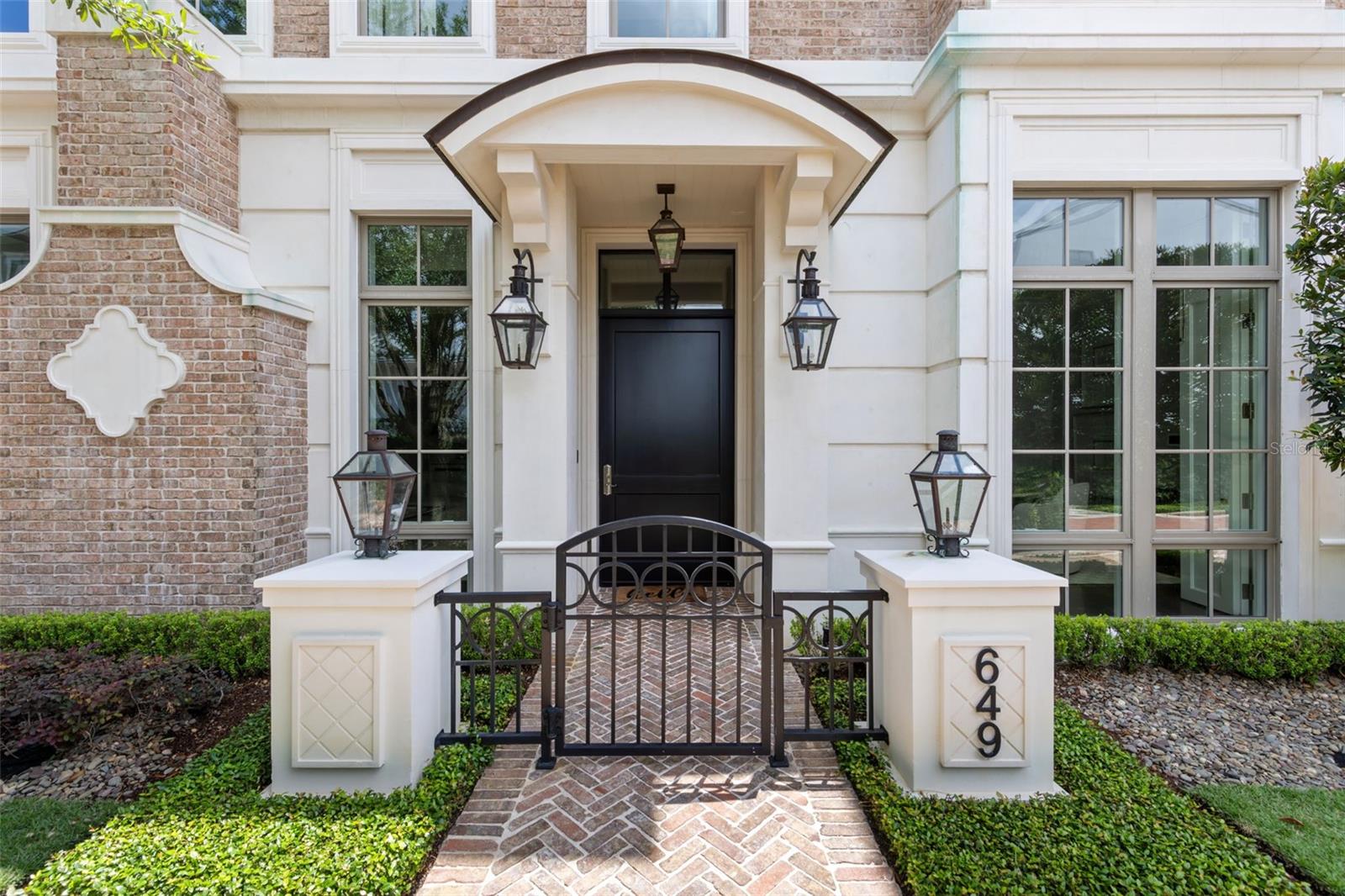 Park Hill is one of Winter Park's most coveted addresses, a distinguished collection of luxury brownstones situated at the northern end of Park Avenue, moments from the city's finest boutiques, restaurants, cultural landmarks and the historic Winter Park Golf Course. Within this exclusive enclave, residence 649 occupies one of the community's most private settings. Beyond the stately brick courtyard and gas lantern-adorned entrance, this three-story home with a private elevator is thoughtfully scaled for refined living. Not oversized, but extraordinarily well-appointed. Ten-foot ceilings, intricate millwork and moldings and generous windows establish an ambiance of quiet elegance, while hardwood floors and designer fixtures carry that standard throughout. The open-concept main living area is built for effortless entertaining. The chef's kitchen features Wolf and Sub-Zero appliances, custom wood cabinetry, marble accents, a center island with bar seating and a wet bar with a beverage refrigerator and ice maker. The space opens directly to a private courtyard with a summer kitchen and dedicated alfresco dining area, creating a genuinely tranquil retreat that feels removed from the energy of the avenue. Upstairs, two guest suites each offer walk-in closets and en-suite baths. A dedicated laundry room and a covered terrace with a fireplace, wet bar and half bath complete the level. The third-floor primary suite provides a true sense of retreat, with two custom walk-in closets, a private balcony and a spa bath filled with natural light from windows and skylights. Dual vanities, a glass-enclosed steam shower and a soaking tub are finished throughout in premium materials. Constructed of Old Carolina brick with three-story block construction, precast exterior trim and a slate mansard roof, the residence features a two-car air-conditioned garage, ample storage and soundproof hollow core floors. With exterior maintenance managed by the association, the lifestyle here is genuinely lock-and-leave. This is a rare opportunity to own in one of Central Florida's most prestigious communities, in a location that simply cannot be replicated.