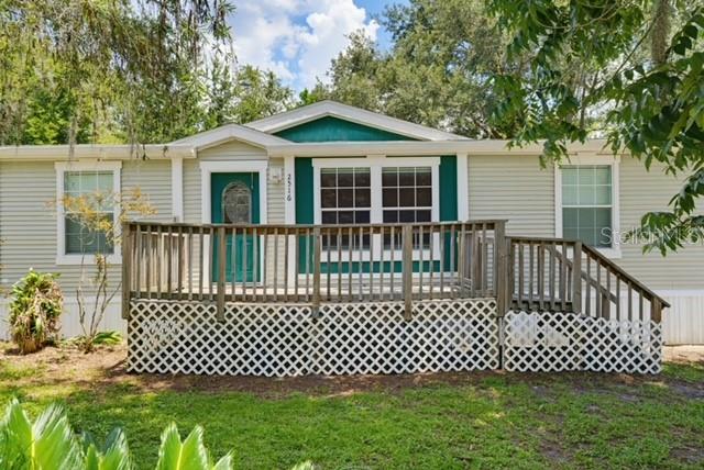 Welcome Home!  This 2009 Palm Harbor Home was beautifully remodeled with gorgeous wood cabinetry, vinyl wood plank flooring in the living spaces and bedrooms as well as ceramic tiled floors in the kitchen and bathrooms, updated paint colors and updated bathrooms. Owner is offering a $5000 appliance credit at closing to add your own touch to this gorgeous and spacious kitchen and laundry room.  The main bedroom has a walk in closet and en suite bathroom with a walk in shower, freshly remodeled with new tile and dual vanity sinks. The front entry has a large wooden deck and mature landscaping. The back porch is screened.  There is a large shed out back for additional storage. There are no back neighbors, just quiet, wooded scenery. The AC was replaced in 2024. Septic, drain field and lift station replaced in 2012. This beautiful home is in a quiet neighborhood in Hillsborough County, yet just minutes from Pasco.