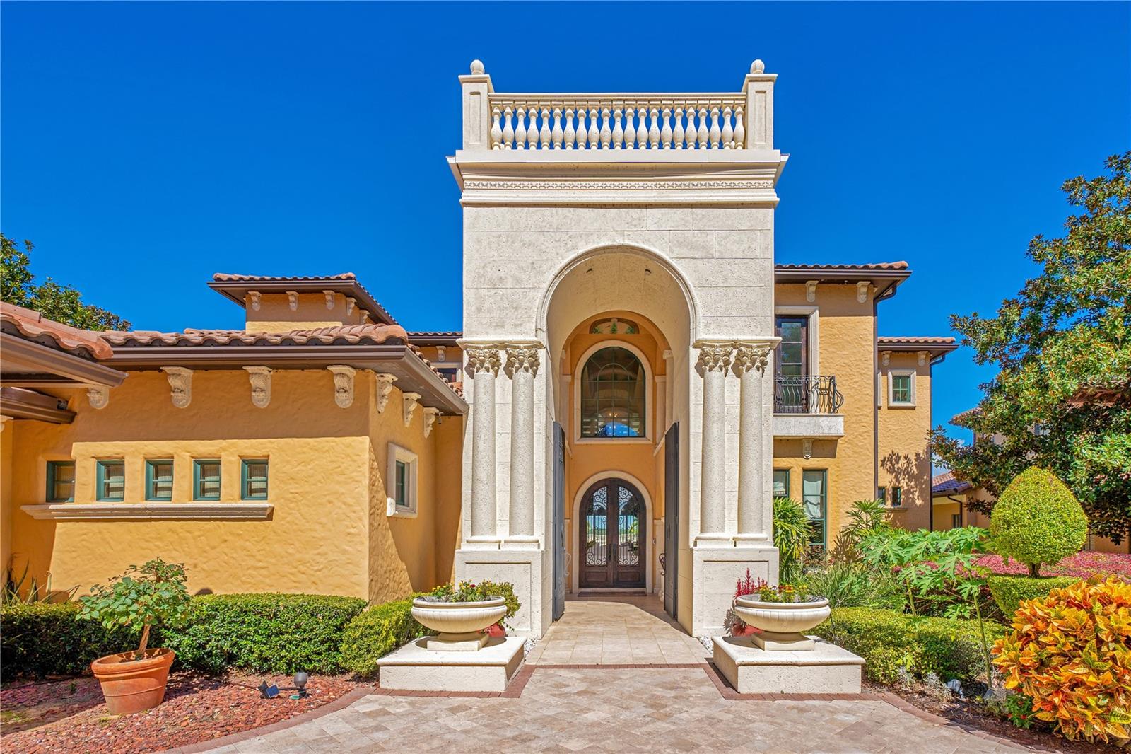 Nestled in the upscale Bella Collina community, VILLA ESPERANZA is the embodiment of grandeur and sophistication. Winner of STREET OF DREAMS, this extraordinary estate invites immediate occupancy and promises delight for its discerning new owner. From almost every room in the house, you'll be captivated by panoramic views of the stunning pool and shimmering Lake Sienna. As you enter, you're greeted by a volume foyer accentuated by exquisite faux paintings and hand-laid marble mosaics. The Living Room features one of two impressive stone fireplaces, both encased with masterful stonework. The Dining Room boasts an arched ceiling adorned with intricate brick overlays. The heart of this Tuscan-style masterpiece is the Dream Kitchen. It's equipped with granite countertops, a professional-grade Wolf gas stove, two dishwashers, a Sub-Zero Pro 48 refrigerator, and a sprawling 20 sq-ft granite-topped island with its own Sub-Zero refrigerator. In the Family Room, a hidden built-in bookcase reveals a 50" LED TV. The first-floor Master Bedroom suite sprawls over 2,500 sq ft and includes a private sitting room with a wet bar featuring a Subzero refrigerator. A see-through fireplace encased in stone adds to the allure. From here, you can gaze out over the spa and Lake Sienna. The Master Bath is equally impressive with his and hers vanities, two separate dressing areas, an 8-head double shower system, and a spacious Jacuzzi tub with an elegant iron canopy. The second floor offers four luxurious Master Suites, a Vegas-style game room, and a full bar overlooking the state-of-the-art theater and the serene lake beyond. The well-appointed theater features a Home Cinema HDR10, 4K wireless projector, and top luxury upholstered seating. Wood-framed accordion doors enhance the theater's acoustic isolation. Overlooking the lake, you'll find a series of balconies, and below, a generously sized heated pool, terrace, spa, and a summer kitchen with a Wolf gas fireplace and hood for culinary enthusiasts. This mansion is equipped with cutting-edge home automation systems, featuring a comprehensive Crestron automation system, Lutron Lighting System, and iQualink for effortless control of the pool via your cell phone. Every detail, from the exquisite woodwork to the stunning stonework and opulent marble, has been executed with unsurpassed craftsmanship. The home is turnkey, boasting essential and luxurious features, tasteful furnishings, imported luxury curtains, beautiful art, and notable pieces like hand-painted Italian artwork gracing the second-floor walls and arches. This is not just a home; it's a masterpiece, a sanctuary, and an opportunity you won't want to miss.