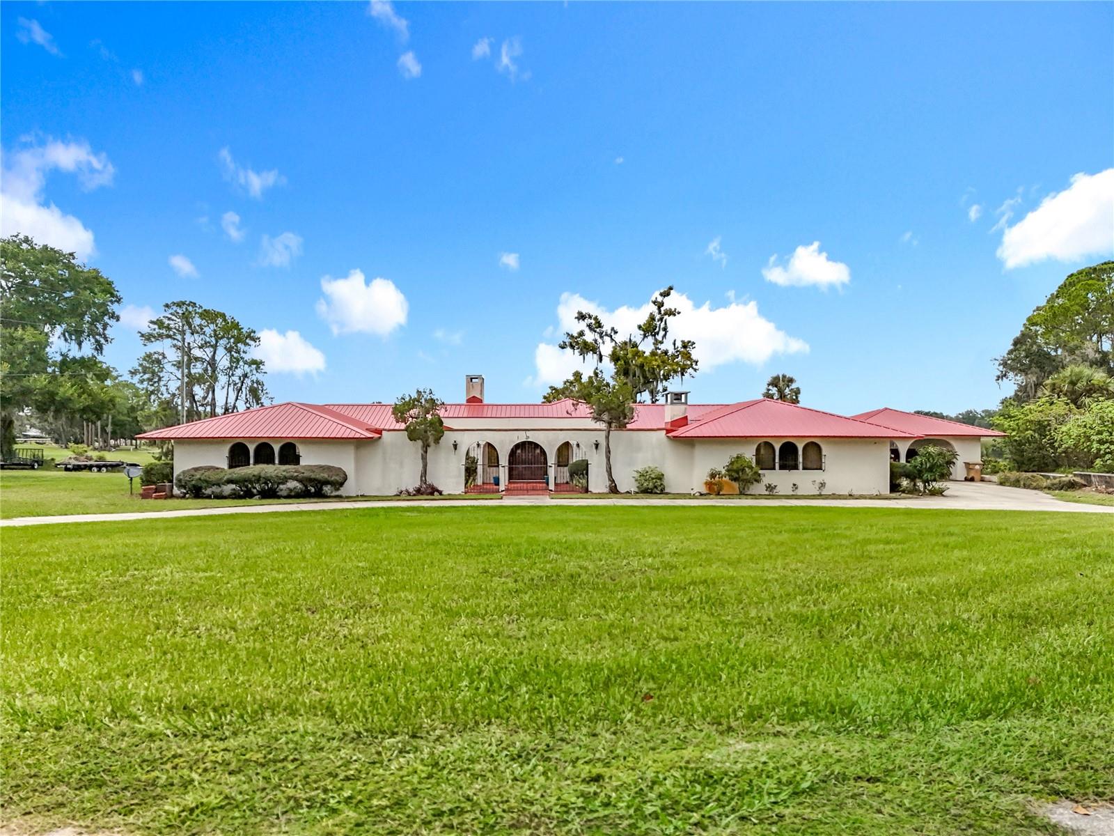 Escape to your own private retreat at 16635 County Road 450 in Umatilla, FL. This unique Spanish-style home sits on 7.5 acres of beautiful land, offering both privacy and room to spread out. With Crescent Lake right in your backyard, you’ll enjoy direct access to one of Central Florida’s hidden gems. Crescent Lake is spring-fed, perfect for swimming, skiing, and a variety of water sports. The property includes its own dock, where you can take in peaceful water views, watch the sunrise, see the seaplanes take off and land or enjoy the abundant wildlife that surrounds the area. The home features classic Spanish-style architecture with charming details that set it apart. A newer metal roof, AC units and septic system.  A 2-car carport provides convenient parking, and the property also includes a detached workshop with endless possibilities. This space could easily be converted into a mother-in-law suite, home office, or guest quarters, adding flexibility to the property. Whether you’re looking for a full-time residence or a weekend getaway, this home delivers the best of both worlds—plenty of land for privacy and outdoor activities, along with the luxury of lakefront living. From boating and fishing to simply relaxing by the water, this property is ideal for anyone who loves the outdoors. With 7.5 acres, there’s room for gardening, hobbies, or even small animals, making it a true homestead with modern conveniences. This home recently appraised for more than asking price, so you'll have instant equity! If you’ve been dreaming of a home that combines acreage, water access, and a one-of-a-kind architectural style, this is a rare opportunity you don’t want to miss. 16635 County Road 450 isn’t just a house—it’s a lifestyle on Crescent Lake.
