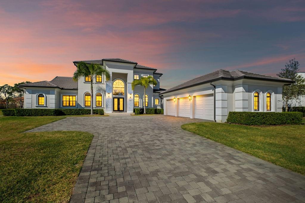 Under contract-accepting backup offers. Welcome to an extraordinary custom residence located within the prestigious guard-gated golf community of Keene’s Pointe, one of Windermere’s most sought-after luxury enclaves.

Built in 2014 and set on an expansive 0.51-acre, this estate offers over 5,000 square feet of refined living space, thoughtfully designed to balance elegance, comfort, and modern functionality. The property enjoys a rare premium setting with serene pond views wrapping both the rear and side of the home, creating a private, picturesque backdrop rarely found within the community.

The residence features 5 bedroom suites, including a luxurious primary suite on the main level along with an additional first-floor guest suite, ideal for multigenerational living or extended visitors. Three spacious ensuite bedrooms are located upstairs, each offering comfort and privacy.

At the heart of the home, the chef’s kitchen is a true showpiece, appointed with top-of-the-line appliances, custom cabinetry, an oversized island, and seamless flow into the main living and entertaining areas. Expansive windows and sliding glass doors flood the interiors with natural light while framing tranquil water views.

Outdoor living is equally impressive, highlighted by a beautiful pool and spa, an extended brick-paver lanai, and a fully equipped summer kitchen, all designed for year-round Florida entertaining. The oversized yard, enhanced by the half-acre lot and pond frontage, provides both privacy and space rarely available in Keene’s Pointe.

Additional highlights include:
• 3-car garage
• High ceilings & architectural detailing
• Hidden pantry
• Office on the 1st floor
• Gas fireplace in the family room and outdoors
• Modern transitional finishes throughout
Residents enjoy 24-hour guard-gated security, lush landscaping, private roads, and optional membership to the Golden Bear Club, featuring golf, dining, fitness, tennis, and social amenities.

Ideally located near top-rated Windermere schools, fine dining, shopping, and major roadways, this exceptional estate represents the pinnacle of luxury living in one of Central Florida’s premier golf communities.
