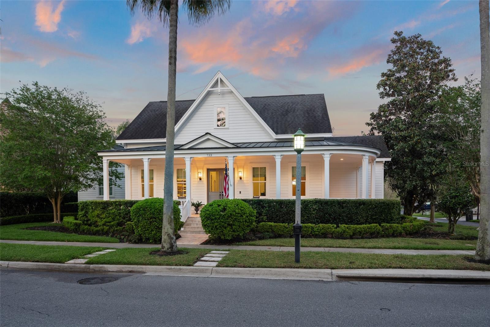 Introducing The White House on East Lawn | A timeless, fully reimagined residence defined by its classic architecture, expansive front porch, and private backyard setting overlooking water and conservation. Inside, the home is designed with a focus on quality, cohesion, and livability. Featuring five bedrooms, each with its own ensuite bath, along with an additional half bath, it offers a rare level of comfort and privacy for both family and guests. The primary suite is located on the first floor, offering a true sense of retreat with serene views of the backyard, pond, and conservation. The spa-inspired bath is finished in marble, featuring a freestanding soaking tub bathed in natural light, a frameless glass shower, and an expansive vanity, creating a space that feels both timeless and indulgent. Additionally, on the first floor are two additional ensuite bedrooms, including a large distinctive multi-room suite ideal for extended family or a secluded guest retreat. A library/office space adds both character and functionality, complete with detailed custom shelving, integrated backlighting, and a whimsical sliding library ladder. At the heart of the home, the kitchen is both refined and highly functional, featuring high-end appliances including a Wolf oven, expansive cabinetry, and a large central island. The large and comfortable family room is anchored by custom built-ins with integrated lighting which creating a warm, cohesive environment ideal for both everyday living and entertaining. The dining room is a true statement space—anchored by a striking, glass-enclosed, temperature-controlled 800-bottle wine room, thoughtfully designed to showcase and preserve a curated collection, and surrounded by rich custom millwork and illuminated stone detailing that create a refined and inviting atmosphere. Adjacent to the wine room and foyer is a sitting area featuring large sliding doors that take you out to the covered patio. Upstairs, two additional ensuite bedrooms are complemented by a dedicated sitting or study area, offering a flexible space for work, study, or quiet retreat. The outdoor living experience is both private and expansive. A covered seating area with retractable screens extends directly from the home, creating a seamless indoor-outdoor environment. The backyard unfolds into a large lawn with a quaint peace garden and a separate fire pit area, all overlooking tranquil water and conservation. Significant recent upgrades enhance both comfort and peace of mind, including double-pane impact-resistant windows, upgraded exterior doors, two new hot water heaters, a new air conditioning system, with the remaining systems and roof being newer. Completing the home is a spacious three-car garage with overhead storage, along with an extended driveway that easily accommodates additional parking. The East Village location offers close proximity to Celebration’s scenic walking trails, a convenient walk to downtown, and is ideally positioned next to the East Village pool and playground. The White House on East Lawn represents a rare opportunity to own a fully turnkey residence, offered partially furnished, that seamlessly blends timeless design, thoughtful renovation, and a serene water and conservation setting.
