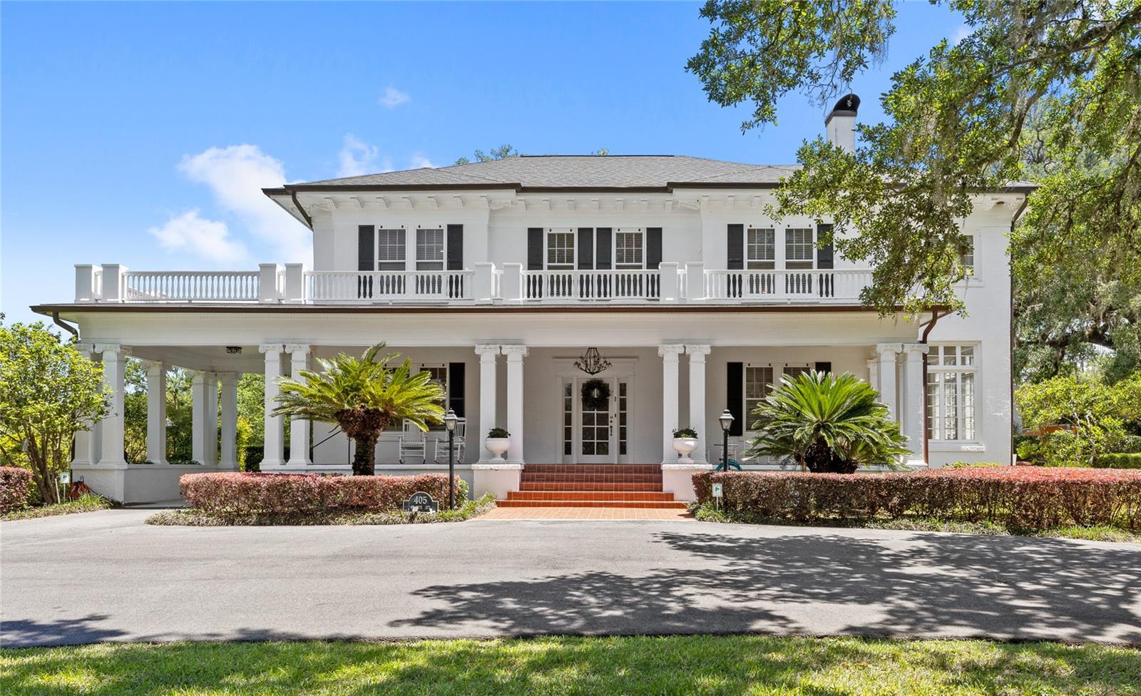 Welcome to this elegant, meticulously maintained historic estate in Ocala, where timeless character meets 2.46 acres of beautifully curated grounds, and is situated just blocks from the charm and energy of Historic Downtown Ocala. This location delivers a rare lifestyle balance: downtown’s restaurants, boutiques, and community events, then return home to your own private retreat framed by space and gardens. The property sits just outside the historic district, giving you the architectural charm buyers love, without the restrictions, so you have the freedom to enhance or expand the exterior over time. For equestrian enthusiasts or those drawn to Ocala’s global reputation, you’re only minutes from the World Equestrian Center. Inside, multiple living spaces are offered, including a formal dining room, a living room with fireplace, and an adjoining sunroom. A separate sitting room with its own fireplace opens to the outdoor patio and deck. Five sunrooms throughout the home flood the interiors with natural light. The custom kitchen offers solid wood cabinetry, granite countertops, a built-in refrigerator, gas range, two ovens, and microwave. A charming breakfast room, mudroom, and built-in office nook are situated off of the kitchen. The downstairs bedroom suite, complete with a private sunroom, features an updated bath with a walk-in shower and soaking tub.
Upstairs, the primary suite offers built-in shelving, dual closets, a private sunroom, and a beautifully updated bath with wainscoting, double vanity, and a large walk-in shower. A fifth bedroom adjacent to the suite provides flexibility as a nursery, office, or sitting room, with its sunroom currently serving as an expansive closet. Two additional guest bedrooms share an updated Jack-and-Jill bath, wrapped in Italian marble. 
Original architectural elements remain intact, including 9–10 foot ceilings, terracotta tile, well-preserved plaster walls, and oak and heart-of-pine flooring. Storage is abundant, with multiple walk-in closets, a cedar closet, and a basement accessible from both inside and out.
A true highlight is the cedar-lined, temperature-controlled 12x19 wine room, finished with travertine floors, a private patio entrance, and capacity for over 2,000 bottles.
Outdoors, a newly resurfaced saltwater pool sits just off the terrace, with convenient access to a nearby half bath. Expansive covered porches and mature landscaping complete the setting, especially with the added benefit of no historic district limitations. Walkable to downtown, minutes to world-class equestrian amenities, and set on a rare oversized parcel. Call today to schedule a private tour.