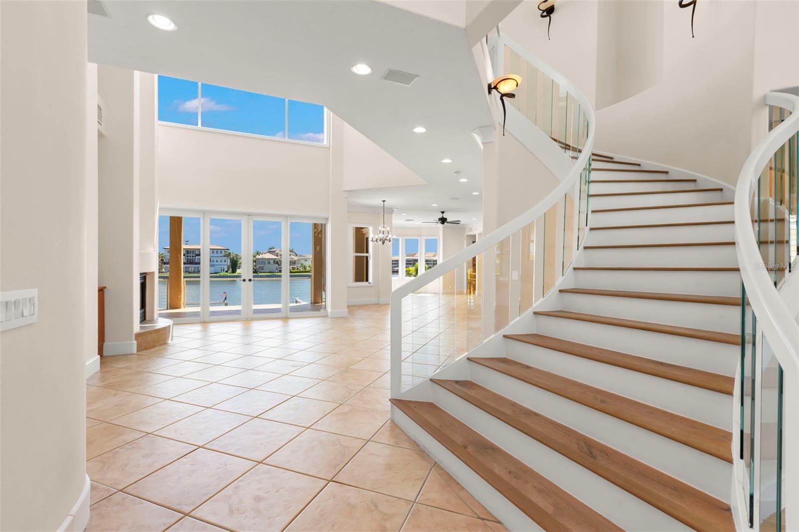 Welcome to a stunning custom waterfront home in the prestigious Kipps Colony within Pasadena Yacht & Country Club. This well built transitional modern masterpiece offers luxury living on deep, protected water just minutes from the Gulf. A circular drive leads to a spacious four-car + garage, with an elevator providing easy access to all levels. The grand foyer opens to formal dining and living rooms with cathedral ceilings and elegant glass railings. The first level of this 5287 SF home includes a waterfront office/bedroom, a media room (5th Bedroom), and a gourmet kitchen with custom cabinetry, granite counters, and top-of-the-line appliances. The master retreat features a morning kitchen, sitting area, waterfront balcony, and a lavish bath with dual sinks and separate soaking tub and shower. Two additional bedrooms with en-suite baths complete the upper level. Breathtaking stained glass windows highlight the front of the home, high ceilings, and expansive glass showcase stunning water views. Outdoor living includes expansive waterfront balconies, an elevated spa spilling over into the pool, a cabana room, and a dock with 16,000 boat lift, perfect for enjoying the sparkling waterway. Offering almost 8000SF under roof and 5 bedrooms, 4 1/2 baths, this home offers something for every member of the family. Experience unparalleled luxury and sophistication in this magnificent home in Pasadena Yacht & Country Club, Pinellas County's only gated, golf course and waterfront community on Boca Ciega Bay. This exclusive club offers fine and casual dining, fitness, personal training, a waterfront heated lap pool, tennis, pickleball, a marina & more. The buyer of this home has the ability to skip the lengthy wait lists and join the club upon purchase. You truly can have it all!