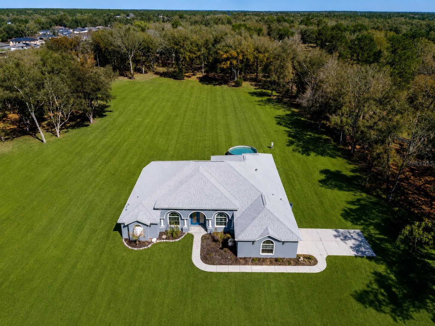 4.65-acre mini farm.   TRUE 4-BEDROOM HOME in one of the most sought-after areas of Rolling Hills, Dunnellon, FL.  This almost new 2,827 Sq Ft home built in 2023 offers lots of privacy and is centrally located 7 minutes from Ocala and 11 minutes to Dunnellon's Rainbow Springs for swimming, fishing, and kayaking. Property is fenced and zoned A1 (agricultural) for your horses. Modern luxurious interior with high ceilings, Palladium windows. High-end finishes throughout, including state-of-the-art Bluetooth-controlled appliances. You will have serious kitchen envy! Granite counters, lots of cabinets, huge walk-in kitchen pantry, with induction stovetop. soft-close cabinets and pull-out drawers. The primary bedroom features a huge bathroom with a ROMAN SHOWER. **French doors lead to SEPARATE OFFICE** A whole-house reverse osmosis (RO) system purifies ALL THE WATER entering the home. LARGE, beautiful LANAI overlooks rolling pasture land. Separate power line is ideal for charging an RV or powering a workshop or a storage shed.  This one-owner home is in pristine condition!
