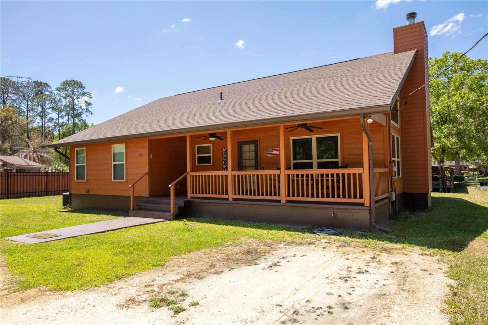 Located in historic Melrose, this 2-bedroom, 2-bath waterfront home offers a prime setting on a canal with direct access to Lake Santa Fe. Inside, the living area is bright and open, with vaulted ceilings and a stone-accented fireplace. The spacious kitchen features updated appliances and granite countertops, with plenty of cabinet space. Enjoy water views from the Florida room, which is perfect for relaxing. From here, step directly out onto the back deck. Take full advantage of waterfront living with your own private dock and covered boat slip, making it effortless to get out on the water whenever you like. A detached garage adds both flexibility and functionality to the property, offering ample space for parking, storage, or even a workshop. Directly across the road, a walking trail leads straight to Santa Fe Lake Park, adding to the home's unbeatable location. Enjoy peace of mind with major updates already completed, including a newer roof, HVAC system, windows, gutters, and flooring. Whether you are looking for a full-time residence or a weekend escape, this location truly sets this property apart.
