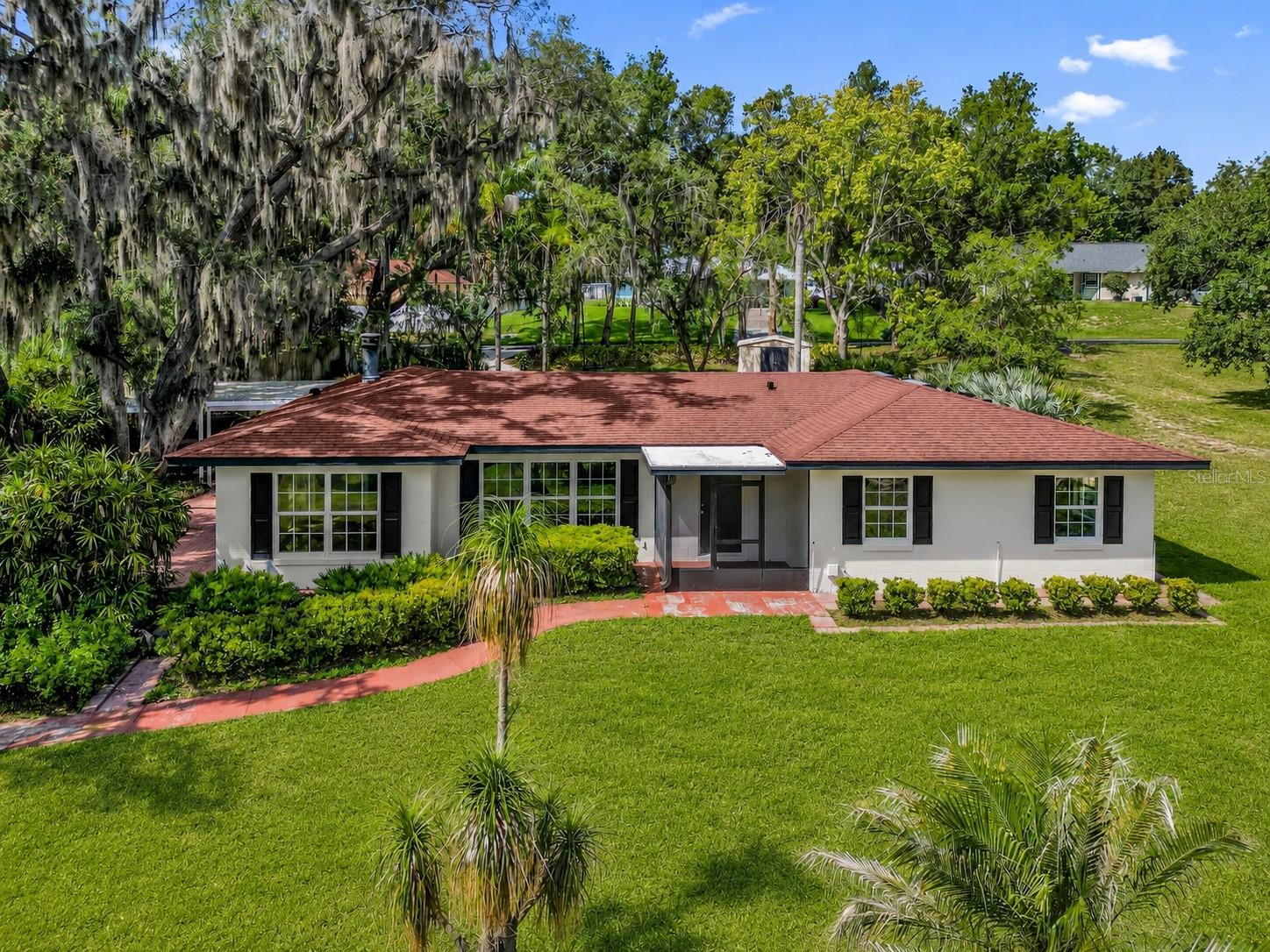 Virtually Staged. Welcome to this beautifully renovated Clermont home, where modern upgrades, major improvements, and a desirable location come together to create the ideal Florida lifestyle. The heart of the home is the fully remodeled kitchen, completed in 2026, featuring a redesigned layout, new soft-close cabinetry, quartz countertops, a designer backsplash, recessed lighting, stainless steel appliances, a large sink, and a brand-new dishwasher.

The bright and inviting living room offers recessed lighting and large grid-style windows replaced in 2026. The dining room features oversized sliding glass doors that fill the space with natural light while overlooking the backyard and mature oak trees. The spacious primary suite includes a walk-in closet with a custom wood organizer and private sliding glass door access to the outdoor living area. Both bathrooms have been completely remodeled with modern vanities, glass shower enclosures, smart mirrors, and updated finishes.

Additional improvements include laminate flooring installed throughout in 2025, new wood trim, and a versatile bonus room with dual sliding glass door access. All sliding glass doors throughout the home, excluding the front entry, were replaced in 2025.

Outdoor living is a highlight of the property, featuring a large screened-in patio with real wood flooring overlooking a peaceful water feature, mature landscaping, and beautiful oak trees. A concrete driveway transitions into a decorative paver carport, enhancing the home's curb appeal while providing ample parking. Residents also enjoy community lake access with a beach, dock, and boat access, offering endless opportunities to enjoy Florida's outdoor lifestyle.

For added peace of mind, in July 2026 the property's wastewater system will be connected to Lake County's Distributed Water Treatment System (DWTS), which is fully owned, maintained, monitored, and serviced by the county. This county-managed system functions similarly to a traditional septic system while eliminating the responsibility of maintaining a privately owned septic system.

Major updates include a complete kitchen remodel (2026), living room windows replaced (2026), laminate flooring throughout (2025), fully remodeled bathrooms, new wood trim, water heater replaced (2026), HVAC replaced (2022), roof replaced (2011), and connection to the county-owned DWTS system (2026).

Ideally located just minutes from Downtown Clermont, you'll enjoy easy access to restaurants, shopping, farmers markets, and community events. Conveniently situated near State Road 50, US-27, and the Florida Turnpike, the home offers an easy commute to Orlando, Walt Disney World, Orlando International Airport, and many of Central Florida's top attractions and employment centers.

Combining extensive renovations, exceptional outdoor living, community lake access, and an outstanding location, this move-in-ready home is ready for its next owner. Schedule your private showing today.