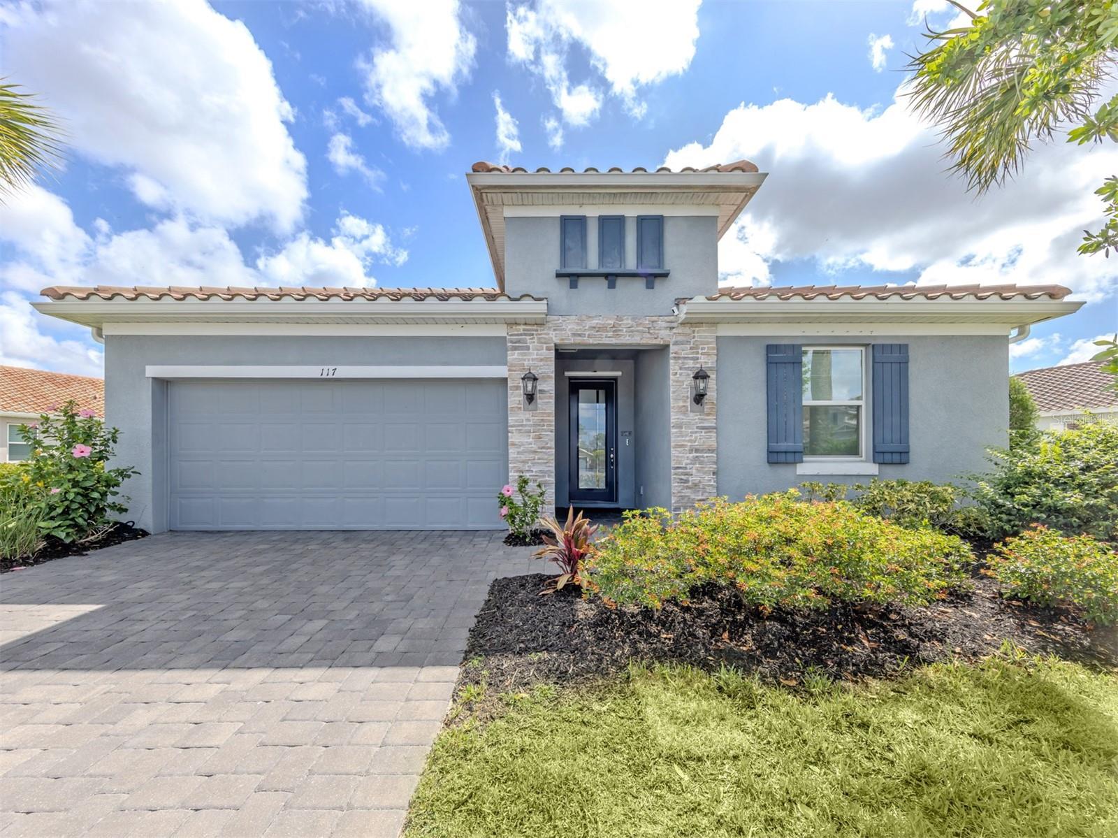 Former model home with exceptional upgrades and resort-style outdoor living now available in sought-after Venice Woodlands! Ideally on a quiet private street ending in a cul-de-sac, this beautifully enhanced residence enjoys a large homesite (0.259 acres) with spacious side yards, offering privacy and an open feel rarely found in newer communities. This stunning home showcases designer interior finishes, cool coastal interior paint colors, a spacious open-concept layout and serene pond-front views. A grand foyer creates an impressive welcome, leading into the chef-inspired gourmet kitchen featuring stainless steel appliances, double ovens, a stylish backsplash, large pantry, abundant cabinetry, and an oversized island overlooking the expansive great room and dining area, ideal for everyday living and entertaining alike. High-end lighting fixtures throughout the home further elevate the sophisticated coastal feel. Designed with privacy and functionality in mind, the split floor plan features three bedrooms toward the front of the home, including one bedroom with its private en suite, while the spacious primary suite is tucked at the rear of the home. In addition, a versatile flex space in the middle of the home offers the ideal setting for a home office, hobby room or den. Go outside to your private backyard retreat featuring a spectacular 15-by-30-foot Indigo saltwater pool added in 2024 with heating and cooling capabilities, all surrounded by an oversized 33-by-40-foot paver lanai designed for Florida living. Additional recent upgrades include a whole-home water filtration system installed in 2024, lush professional landscaping and thoughtfully designed outdoor living spaces. Other highlights include energy-efficient construction and a beautifully maintained gated community surrounded by lakes and wooded preserves. Residents enjoy access to resort-style amenities including a clubhouse, fitness center, pickleball courts, bocce ball and community pool. Ideally with easy access to Interstate 75, downtown Venice, Sarasota, beaches, dining, shopping and within the highly regarded Sarasota County A-rated school district, including Laurel Nokomis School and Venice High School.