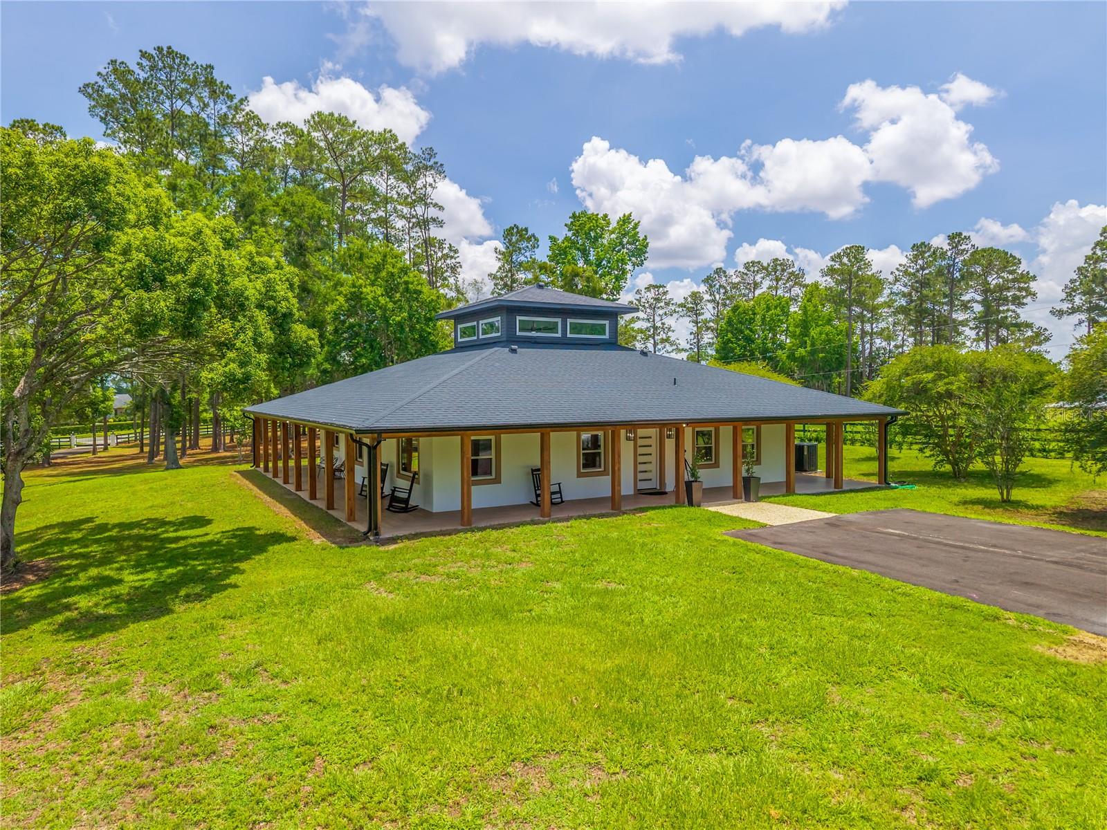 This move-in-ready, gated 5.58-acre farm is ideally situated along the highly desirable Highway 225 in the heart of Ocala’s renowned horse country. Located in the sought-after Northwest Ocala region, this property offers the perfect blend of modern comfort and equestrian living. Surrounded by established horse farms and free from HOA restrictions, the fully fenced property features lush paddocks with automatic waterers, mature shade trees, a natural pond, a gas fire pit, a generator, and a peaceful, private setting.

At the center of the property sits a beautifully updated American Four Square home with a distinctive belvedere and a wraparound porch, perfect for enjoying Florida’s year-round outdoor lifestyle. Offering 2,590 square feet of thoughtfully redesigned living space, the home includes 4 bedrooms, 2 bathrooms, and a den, all enhanced by high-end finishes throughout. The second-floor belvedere offers versatile living space with a closet, making it ideal as a fourth bedroom, home office, media room, or hobby space. Tile flooring extends through most of the home, while abundant windows fill the interior with natural light. An electric fireplace, decorative wood accents, and custom window treatments create a warm and inviting atmosphere.

The fully renovated kitchen is both stylish and functional, featuring stainless steel appliances, granite countertops, a tiled backsplash, ample cabinetry, a pantry, and a spacious center island. The open-concept design seamlessly connects the kitchen, dining, and living areas, creating an ideal space for entertaining family and guests.

Equestrian amenities include a solid three-stall concrete block barn with stall mats, tack room and a convenient walk-out design that opens directly to a large established pasture. It includes a natural pond equipped with an aerator and two paddocks. The acreage also provides ample room to add additional paddocks, an arena, or other equestrian improvements to suit your needs.

A separate one-bedroom, one-bathroom apartment located within the barn offers comfortable accommodations for family, friends, guests, or farm help.

Conveniently located just minutes from Highway 27, the property provides easy access to feed and tack stores, veterinary services, and equine professionals. Both HITS Ocala and the World Equestrian Center are approximately 10 minutes away, placing world-class equestrian competition and amenities within easy reach.

This is a rare opportunity to own a fully updated farm in the Horse Capital of the World®, where comfort, convenience, and exceptional equestrian living come together seamlessly.
