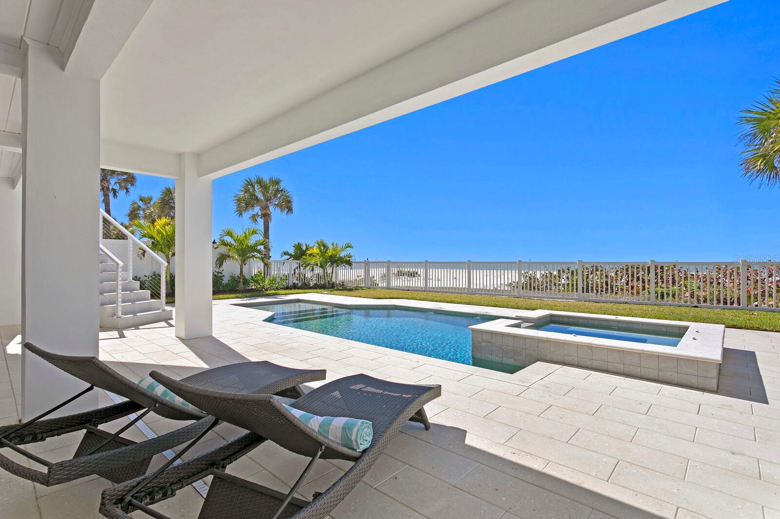 WELCOME TO THE ONLY BRAND NEW COMPLETED GULF FRONT HOME FOR SALE ON THE ENTIRE WEST CENTRAL COAST OF FLORIDA. GATED BEACHFRONT ESTATE WITH A RARELY FOUND PRIVATE DOCK ON THE INTRACOASTAL WATERWAY. Welcome home to the epitome of coastal luxury in this outstanding Indian Rocks Beach location boasting Modern Key West-inspired design by renowned Matta Architecture, a magnificent Gulf beach, and unobstructed panoramic views of the Gulf and Intracoastal. In addition to the dune-protected pristine beach, this unique family retreat features a new gated private dock with 20,000# boat lift on the beautiful Intracoastal Waterway. Built to the latest building codes with full exterior concrete block and steel reinforced foundation construction, impact windows/doors, and elevated FEMA-compliant living for flood risk reduction and optimal insurance premiums. Enjoy refined finishes and superior appointments throughout with over 9,551 Total Square Ft/ 5,825 SF Under Air which includes an oversized garage with parking for 6 cars and 3 stop Elevator. From the Mahogany front door to the custom contemporary cabinetry, the professionally designed interior takes full advantage of abundant natural light and outstanding water views from every room. An open floor plan offers an intimate entry, Great Room with LED cove ceiling lighting, 80-inch Modern Flames fireplace, expansive beachfront and intracoastal terraces and panoramic views. The refined kitchen is designed for seamless entertaining with top-of-the-line appliances, (Bertazzoni/Fisher & Paykel/Thermador) and custom finishes, a surround dining island and additional center island, luxurious Cachoeiro white marble countertops, 48-inch freestanding 6-burner gas range with griddle, dining area and an entertaining bar with prep sink, wine refrigeration, beverage center and ice maker. Living spaces include 5 ensuite bedrooms, a private office, flex room and laundry room on each living level.  The top level Primary Retreat delivers on the best of privacy, appointments and views. Elegant accommodations include full retracting glass doors to full width private terrace and spectacular sunsets, adjacent sitting room with Gulf views, morning bar w/ sink, beverage center and terrace access, gracious his/hers closets and a stunning spa-inspired bath featuring dramatic finishes, Bianca Dolomite counters, a soaking tub and impressive dual shower. Immerse yourself in outstanding Florida coastal living outdoor oasis with a choice of entertaining areas, multiple terraces, expanded covered lanai, PebbleSheen saltwater pool and spa, Omni-Logic pool controller, LED lighting and Ivory Shellock pool deck where you can experience the sights and sounds of this unmatched beachfront location. Reinforced construction includes superior energy efficiency, smart home features, Hardie Plank siding, High Efficiency LG HVAC, premium Low-E impact windows/sliders, CAT6 wiring (cameras, WiFi and sound), natural gas, tankless water heater, whole house 22KW generator, oversized 6 car garage pre-wired for 2 EV charging stations, lush landscape and more. Note: This home is built to superior V zone standards and located in a more favorable AE flood zone, providing better safety and lower insurance premiums. Indian Rocks Beach offers a quiet, laid-back atmosphere with miles of sandy beach, yet remains convenient to the larger cities of Tampa, St Petersburg and Clearwater.  Zoned to allow short term rentals if desired.