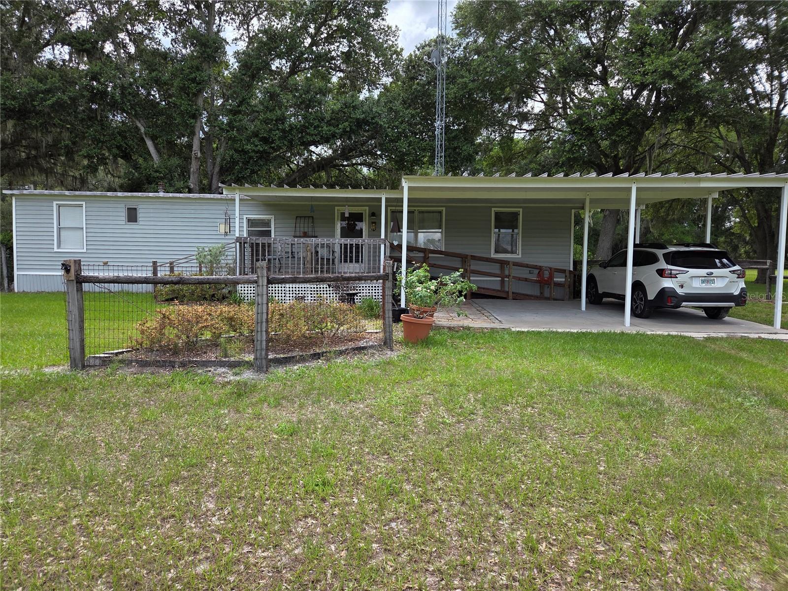 BEAUTIFUL FLOWING GREEN PASTURES WITH 2 PADDOCKS ON OVER 5 ACRES:  Property is completely fenced with barbed wire and wood posts. Single-wide mobile home with 2 bedrooms and 1.5 bathrooms. Clean, open concept living room and kitchen with eat-in dining room. Regular cabinets and laminate counter tops. Laundry room in hallway with washer and dryer. Front porch is approx. 11.7 x 11.9 and fenced for your animals with wood decking and handicap ramp. One car carport or 2 small cars. Fairly new 8 x 10 Shed with a loft could be used for storage or a workshop/office. Pole barn has 5 stalls and a tack/feed stall. Stalls are approx. 12 x 12 and entire barn is appox. 36 x 24 with water and electric. Back wood deck with metal roof. Mobile has a metal roof and a new HVAC system. Updated flooring and new insulation with new siding. Updated toilets and vanities. Zoned Agricultural/Rural Residential and is a partial flood zone A. Seller has lived their for 16 years and has had no problems with flooding. Septic was pumped out in November of 2025. SECO for electric and Dish for TV.