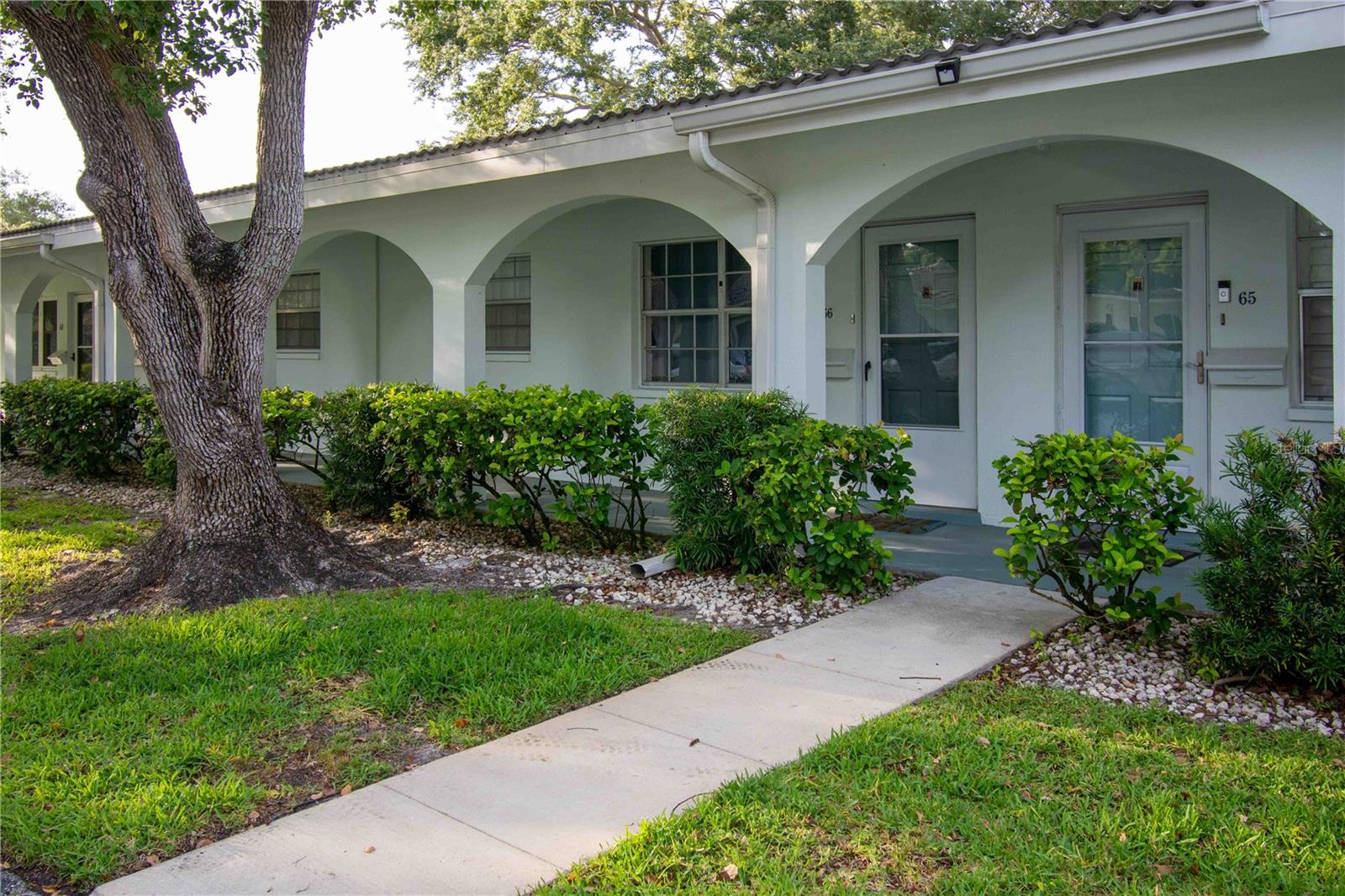 Twin Oaks is a well-kept, well-maintained 55+ community in the heart of Seminole, offering low-maintenance living just minutes from award-winning Gulf beaches and Seminole City Center. This spacious 2-bedroom, 2-bath villa is one of the few units in the community with both a covered carport and a dedicated parking space, and it includes a south-facing rear patio — a quiet spot for morning coffee or an evening refreshment as the light shifts.
The living and dining areas are filled with natural light and flow seamlessly into a bright bonus Florida room at the back of the home, ideal as a den, home office, hobby space, or second sitting room. The primary bedroom is quietly positioned toward the rear for added privacy and includes dual closets, an ensuite bath, and sliding door access to the bonus room. The guest bedroom is equally comfortable with an adjacent full bath, making it a natural fit for visiting family or overnight guests. An interior laundry closet with a stackable washer and dryer plus built-in storage adds everyday convenience.
Mechanically, the home is in solid shape: the tile roof was replaced in 2022, the HVAC in 2018, the dishwasher in 2024, and the wastewater drain line from the unit to the main line was replaced in 2018.
The HOA fee covers nearly everything except electric, keeping monthly budgeting straightforward. The community pool, clubhouse with a small kitchen and library, and shuffleboard courts give residents an active social calendar year-round, with Bingo, Pinochle, coffee hours, and more. Central Pinellas puts you close to shopping, dining, the Seminole library, USF St. Pete, the Post Office, and Seminole City Center, with Indian Rocks Beach just a short drive away.