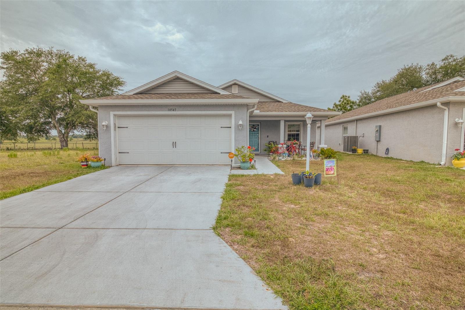 Tucked away in the peaceful gated 55+ community of Tarawood in beautiful Floral City, this 3-bedroom, 2-bath home offers the perfect blend of comfort, nature, and carefree Florida living. Step inside to a bright open-concept design filled with natural light and welcoming spaces ideal for relaxing or entertaining. The kitchen shines with granite countertops, abundant cabinetry, and an upgraded Samsung stainless steel French door refrigerator. The spacious primary suite features a large closet and private bath with a walk-in shower, while the additional bedrooms provide plenty of room for guests, hobbies, or a cozy home office. Out back, the screened lanai is your own private retreat overlooking peaceful pasture views that fade into a lush forest backdrop — the perfect place for morning coffee, evening wine, and everything in between. Tarawood residents enjoy fantastic amenities including a clubhouse, pool, fitness center, and game room, all with an affordable HOA of just $190/month. Say goodbye to high electric bills — this incredible solar panel system will be completely paid off by the seller at closing, giving you energy savings from day one! Located near the Withlacoochee State Trail, scenic lakes, and the historic charm of downtown Floral City, this move-in ready gem offers the laid-back Florida lifestyle you’ve been dreaming of.