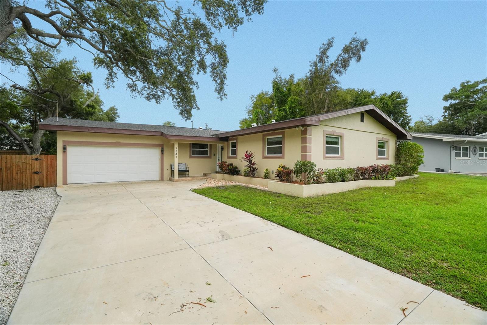 Fully renovated 4-bedroom, 2-bathroom home with a 2-car garage on nearly one-third of an acre and no HOA. This move-in-ready property features an open-concept floor plan, wood-look tile flooring throughout, and a beautifully updated kitchen with quartz countertops, a center island, stainless steel appliances, and a suspended range hood. Major improvements completed in 2023 include a new Roof, double-pane Windows, HVAC system and ductwork, electrical Panel, Plumbing, Water heater, impact Garage door and opener, Driveway, Fencing, Irrigation system, Landscaping, and interior/exterior Paint. New Septic system 2025. The oversized fenced backyard offers endless possibilities, with plenty of room for a pool and outdoor living space, a fire pit, RV/Boat, or other recreational vehicles parking. The extended driveway provides abundant parking for guests and gatherings. Ideally located within walking distance of BayCare Ballpark, home of Phillies Spring Training, as well as the Joe DiMaggio Sports Complex, Long Center, Ream Wilson Trail, and Duke Energy Trail. Convenient access to Clearwater Beach, Downtown Clearwater, St. Petersburg, Tampa, St. Pete-Clearwater International Airport, and Tampa International Airport makes commuting and recreation easy. A rare opportunity to own a fully updated home with substantial outdoor space in a central Clearwater location.