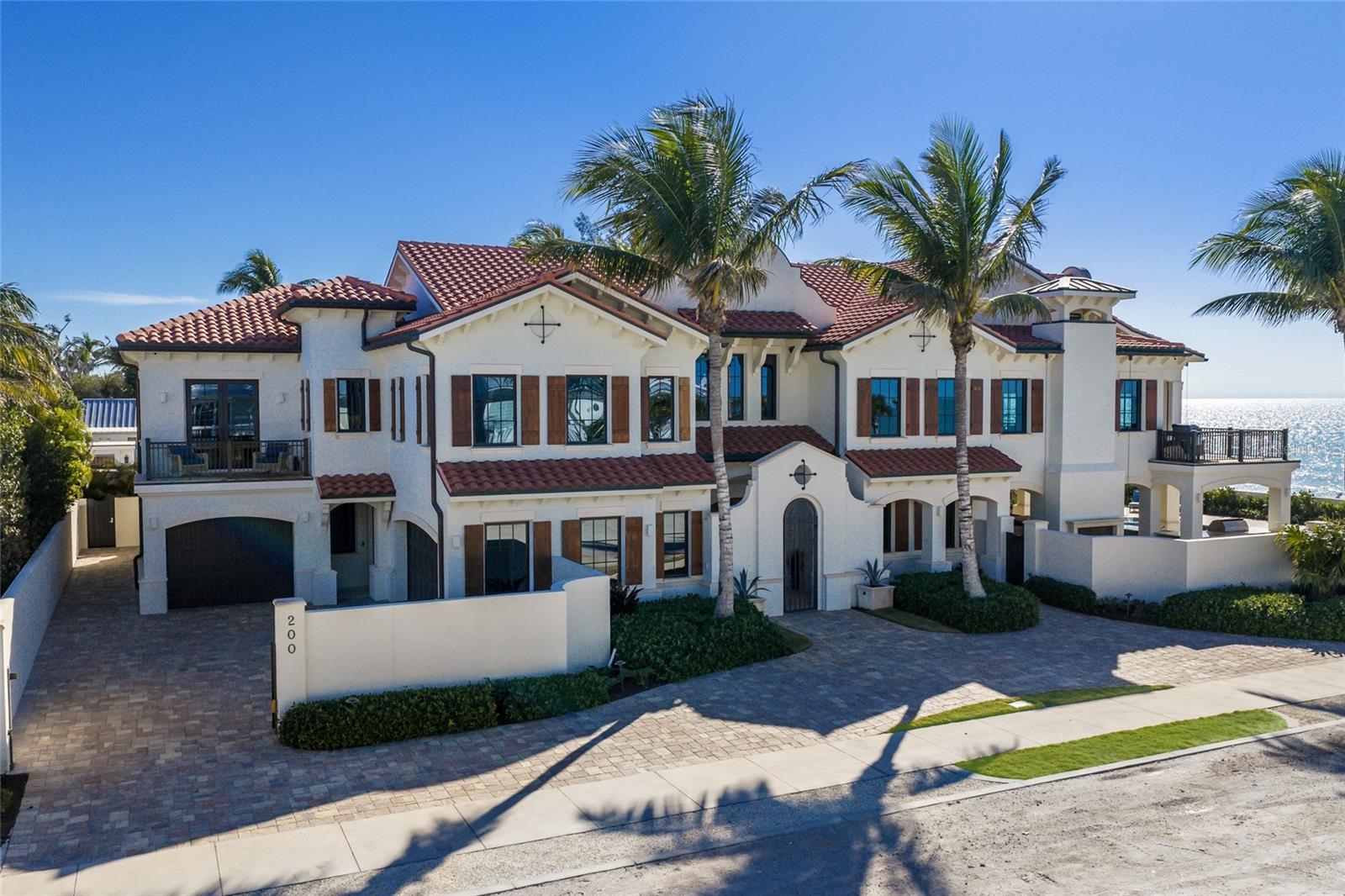 Ensconced within the historic district of Boca Grande, this exquisite beachfront residence embodies the pinnacle of coastal living. Privately walled and boasting nearly 100 feet of pristine Gulf frontage, this 4-bedroom, 4.5-bath home offers sweeping water views and understated elegance. Built in 2016 by Yusk Construction, renowned for impeccable craftsmanship, the residence encompasses 4,533 square feet of main living space, complemented by additional workout and recreational areas.
Professionally interior designed by Chelon Faustine Rieniets, the home showcases a harmonious blend of timeless design featuring hand-selected tile details, intricate custom ceiling treatments, elegant cabinetry, and wide-plank wood floors throughout. The Gulf-front kitchen, appointed with top-of-the-line appliances, stone and wood countertops, and a striking double island, seamlessly flowing into the formal living room with a gas fireplace. The home is complete with a family/media room, 4 ensuite bedrooms, private office and powder room. 
Outdoor living is equally exceptional, with a Gulf-front covered porch equipped with remote-controlled shutters and screens, private balconies off select rooms, and a waterside pool. An expansive covered patio with summer kitchen and two-sided fireplace creates the ideal setting for unwinding while enjoying breathtaking panoramic sunsets over the Gulf. Additional features include quality construction, elevator, whole-house generator, and storm-resistant windows and doors. Located just a short walk from the charming village of Boca Grande, this extraordinary property offers the rare combination of privacy, luxury, and convenience in one of Florida’s most coveted coastal destinations.