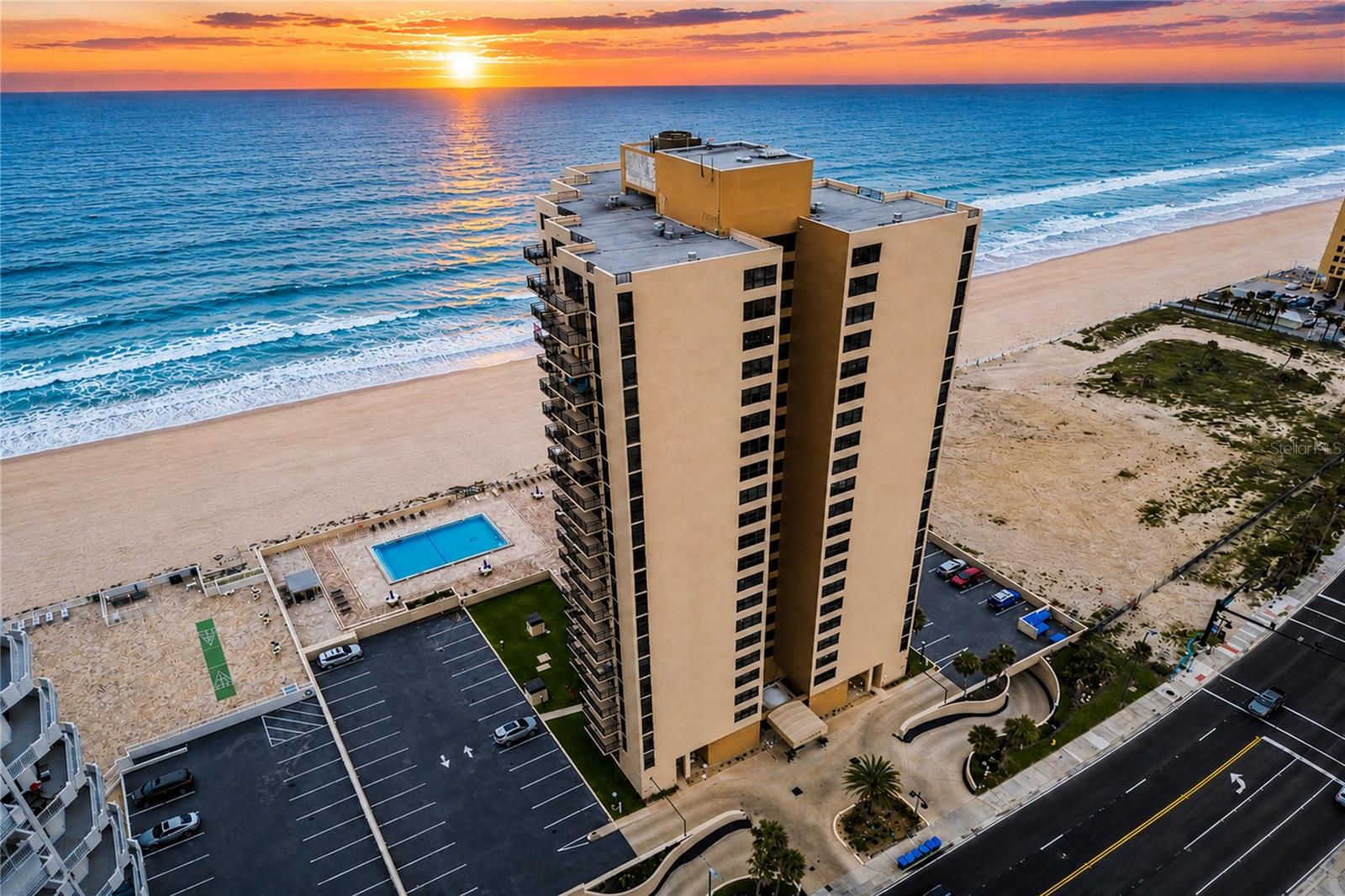 Welcome to Unit 2106 at Oceans One**, where breathtaking oceanfront living meets everyday convenience in the heart of Daytona Beach Shores. This beautifully maintained condominium is **truly turnkey**--being offered **completely furnished**, allowing you to move in and immediately begin enjoying the Florida lifestyle. The spacious interior features **tile flooring throughout**, **granite countertops**, **stainless steel appliances**, and **electric blinds in the living room** for effortless comfort and convenience. One of the home's standout features is the **open kitchen**, thoughtfully redesigned by opening it to the living room to create an inviting floor plan. This seamless layout provides wonderful flow throughout the main living area, allowing you to prepare meals while visiting with family and friends instead of feeling separated in the kitchen, making it the perfect setting for both everyday living and entertaining. The unit has been meticulously cared and offers newer windows and sliding glass doors, providing peace of mind while maximizing the spectacular panoramic views. From your private balcony, you'll enjoy breathtaking sunrises over the Atlantic Ocean and equally impressive views of the Intracoastal Waterway, where you'll be treated to beautiful sunsets at the end of each day. An added convenience is the **laundry room located just outside the front door**, shared by only a few neighboring residences, offering the convenience and privacy of having laundry just steps away without sacrificing valuable interior living space. Oceans One is a well-maintained oceanfront condominium featuring a heated swimming pool, direct beach access, secure entry, underground assigned parking, additional storage, a social room, fitness center, and beautifully maintained grounds. The building's three-month minimum rental policy helps preserve a quiet, residential atmosphere without the constant turnover associated with short-term vacation rentals. One of the greatest advantages of this location is its exceptional walkability. Just across the street you'll find Publix, Walgreens, the Daytona Beach Shores Community Center and Senior Center, along with pickleball courts, golf, parks, and a wonderful selection of restaurants and cafés. Whether you're picking up groceries, meeting friends for lunch, or taking an evening stroll on the beach, virtually everything you need is just minutes away. Whether you're searching for a full-time residence, a seasonal retreat, or a second home, Unit 2106 offers an exceptional combination of comfort, convenience, spectacular ocean and Intracoastal views, and the relaxed coastal lifestyle that makes Daytona Beach Shores such a desirable place to call home. Simply unpack your suitcase and start enjoying everything this exceptional oceanfront residence has to offer. The monthly condominium fee provides exceptional value and includes cable television, high-speed internet, water, sewer, trash removal, building insurance, exterior building maintenance, grounds maintenance, heated pool maintenance, common area upkeep, pest control, secure building access, and professional property management--making oceanfront living both enjoyable and virtually maintenance-free. Sharks coating added to entrance of building, including going and coming from garage area.