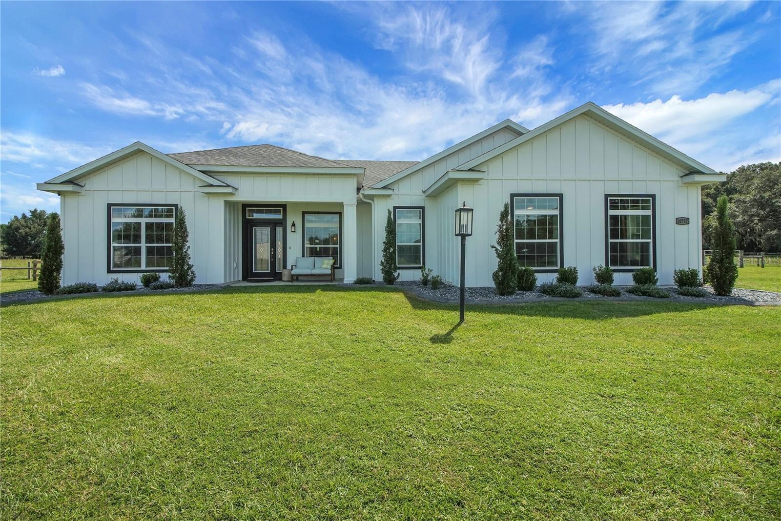Country living at its finest! Nestled on over 10+ lush and mostly cleared acres in desirable Oxford, this custom 4-bedroom, 3-bath salt water pool home with bonus room is a true showstopper. Built in 2021 with BLOCK construction and Hardieboard siding, the home offers over 2,700 sq. ft. of thoughtfully designed living space. Step inside to find luxury vinyl flooring, crown molding, high ceilings, and 5-inch baseboards throughout the main areas. The open, split floor plan is ideal for entertaining, featuring a chef-inspired kitchen with quartz countertops, stainless steel appliances, white cabinetry, a farmhouse sink, crown accents, and a cabinet pantry. The spacious living room overlooks the sparkling saltwater pool and wide-open views beyond. The primary suite is filled with natural light and includes a spa-like bath with dual sinks, granite countertops, a corner soaking tub, and a beautifully tiled shower. The versatile bonus room includes a closet and private outdoor access—perfect as a game room, guest suite, or additional bedroom. Guest baths are equally impressive with granite counters, white cabinetry, and stylish tile shower & shower/tub combo.  Step outside to your own private retreat! Enjoy the resort-style pool with sun shelf, paver decking, and plenty of space to host family and friends. With 10+ acres, there’s more than enough room for pets, toys, and the lifestyle you’ve been dreaming of.
