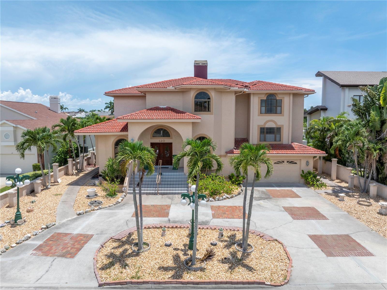 Your beautiful waterfront home awaits you in Tierra Verde! Pull into the u-shaped driveway and be welcomed by a large garage with 4 car parking and double front doors with intricate glass design. Upon entry you are greeted by high ceilings in the entry way, towards your left is a large formal dining room and to your right leads you to a spacious living room and family room combo with wet bar and 360-degree wood burning fireplace. Just off this space is a full bathroom with outdoor access.  Step through the sliding glass doors onto the back patio, and take in the view of the pool, deep water waterfront canal, wooden dock, and looking towards the east enjoy the view of the open water and Skyway Bridge in the distance. The kitchen features a large u-shaped island with cook top and sink, all the way around is bar top seating. Off the kitchen is a built-in desk area and separate laundry room. Ascend to the second floor and enter the private large master bedroom with dual closets, access to outdoor space, and large bathroom with dual sinks, large soaking tub, and separate shower stall. The 3rd floor features a matching bedroom with en suite bathroom as the second floor, but with access to the balcony where you can take in the outdoor views. Travel down the hall to a another large bedroom with en suite bathroom featuring a large wood burning fireplace, walk in closet, and tub with shower combination. At the end of the hall, you will find another full bathroom and two additional bedrooms, both with walk in closets and sliding glass doors leading you to the shared balcony at the rear of the house. Your new home awaits! No interior flooding following Hurricane Helene