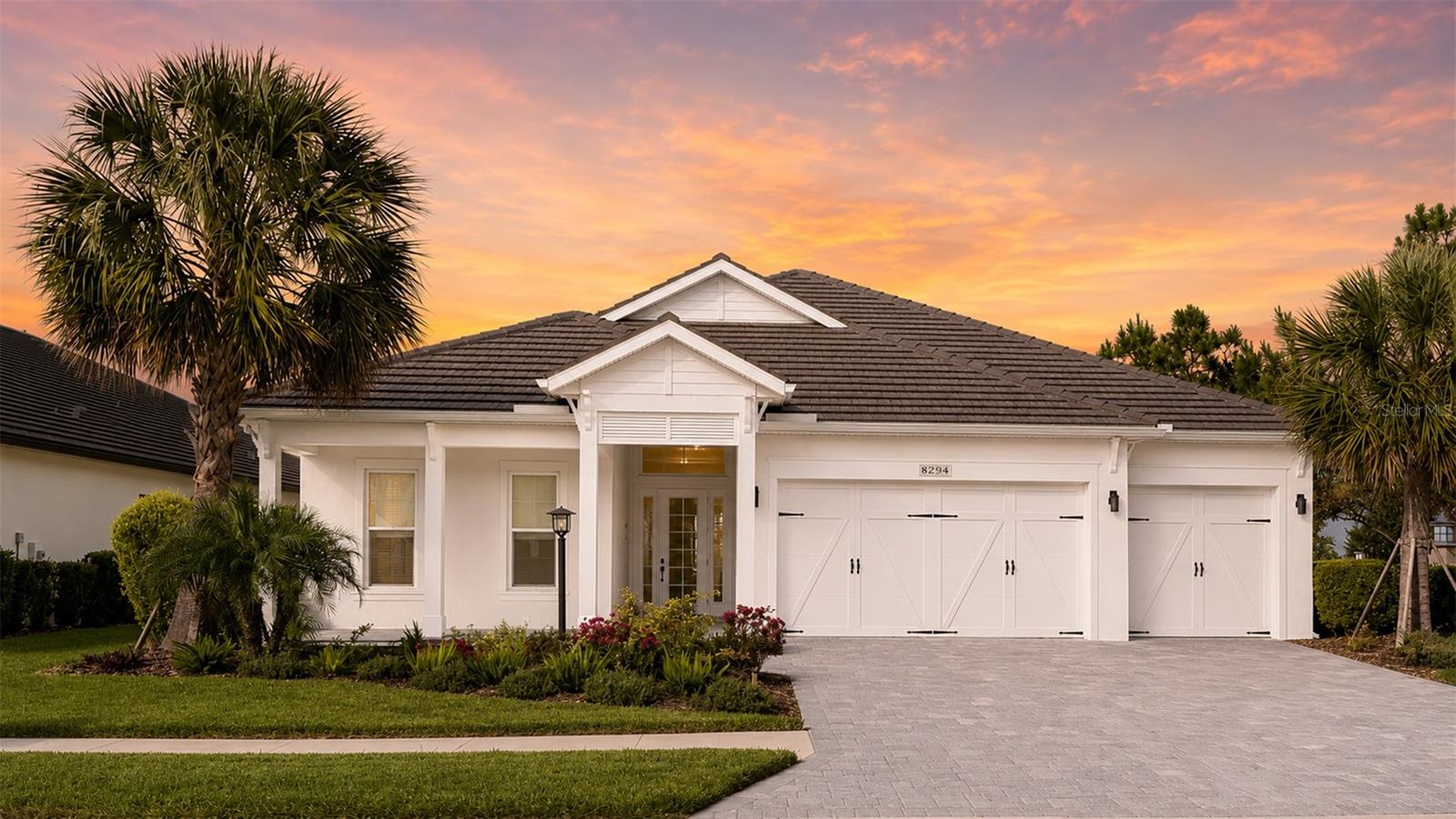 Modern sophistication meets Lakehouse Cove living in this beautifully customized, design-forward three-bedroom plus den Outrigger plan, offering a rare contemporary aesthetic in one of Waterside's most sought-after neighborhoods.  Thoughtfully finished with clean lines, dramatic accents, and elegant designer details this home is ideal for buyers seeking something distinctive.  The kitchen makes a striking statement with 3-inch quartzite countertops, a waterfall island with LED accent lighting, cooktop, wall ovens, and an indoor/outdoor serving bar.  The great room features 48"x48" tile flooring, tray ceilings, surround sound, and a sleek feature wall with built-in fireplace, TV and black granite surround.  The bright and spacious primary suite offers a peaceful retreat overlooking beautiful pond and landscape views, with a generous walk-in closet, dual vanities, and a large walk-in shower.  Two additional bedrooms each offer walk-in closets, while the centrally located den with custom barn door provides the perfect space for a home office or media room.  Outdoor living is equally inviting with a large covered lanai overlooking the pond and lush landscaping - perfect for entertaining or relaxing in privacy.  Additional highlights include a 3-car garage and a large private backyard.  Enjoy the exceptional lifestyle of Lakehouse Cove, with its resort-style amenities and access to Waterside Place, UTC & Downtown Sarasota.  A unique opportunity for the buyer who appreciates contemporary elegance in a premier Lakewood Ranch location.