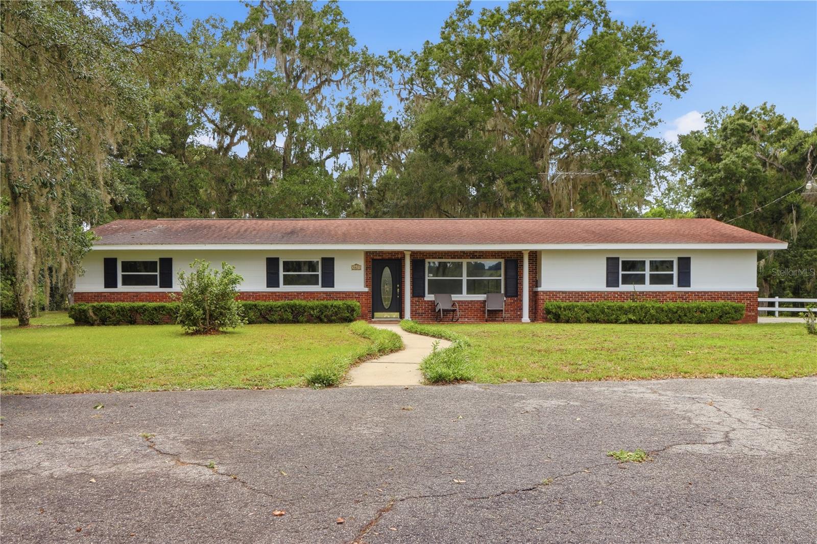 The opportunity to own 25.0 acres in Spring Lake with 3/2 home is a rare opportunity! Along with the home, you have a large detached garage with two roll up doors, another large workshop or storage shed, dog pens, 3 small ponds, whole house generator, home security system, water filter, beautiful azeleas, a tennis court that needs resurfacing (but would make an excellent floor for a pole barn) Sit in the living room and enjoy the beautiful pastures and wildlife. Fish in your ponds and enjoy 12.5 acres of green belt tax property for your cows and horses. Property is fenced and cross fenced, so bring your livestock and move in! Wooden fence with two solar panel coded gates for your added privacy on your circular drive. Plenty of parking for boats, RV and vehicles and room for a pool. Near I-75 for commute to Tampa, Wesley Chappel, Dade City and Zephryhills. Convenient to hotels, grocery stores, shopping and restaurants on corner of Hwy 50W and I-75. Hurry... this one won't last long. Property is high and dry... no worrying about flooding or standing water.