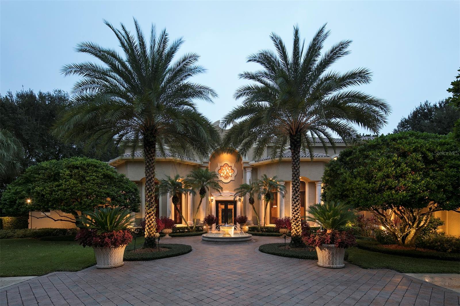 This exquisite estate, built by Pelligrini Homes, sits along the front nine of Isleworth championship golf course and provides breathtaking views of Hole 6. Boasting 6,115 square feet of beautifully curated living space on an oversized lot, this home has been fully restored to the original esthetics from builder designs. Custom ceilings, travertine floors adorned with intricate tile inlays, and carefully crafted shell stone columns are just a few of the distinctive features that elevate this residence. The grandeur of the formal living room is accentuated by its soaring 20-foot ceiling, complemented by a magnificent chandelier and a stately stone fireplace. The heart of the home lies within the chef's kitchen, where custom cabinets, professional-grade Wolf, Thermador, Bosch and Sub-Zero appliances, and granite countertops converge to create a culinary haven. A beautiful groin-vault ceiling adds to the allure while allowing direct access to both the casual dining nook and the formal dining room with a built-in bar for effortless entertaining. The family room, which has an open and airy layout, has a built-in media display and seamless access to the lanai. Retreat to the main-level owner's suite, where a cozy fireplace, dual closets, and a lavish bath await, featuring dual vanities, a walk-in shower, and a luxurious soaking tub enveloped by elegant stone columns. Additional interior highlights include a distinguished home office trimmed with knotty pine wood, a versatile bonus room, and a spacious laundry room outfitted with custom cabinetry. Upstairs, the remaining bedroom suites open onto a sprawling balcony, offering panoramic views of the golf course and the sparkling waters of Lake Bessie. Outside, a haven of relaxation awaits, complete with an open-air swimming pool, a private putting green, and ample deck space surrounded by meticulously maintained landscaping. The European-style lanai, with a graceful balustrade, provides the perfect setting for al fresco gatherings and captivating sunsets against the backdrop of the golf course. This estate epitomizes the ultimate in golf-front living with its unparalleled blend of luxury, convenience, and breathtaking surroundings.