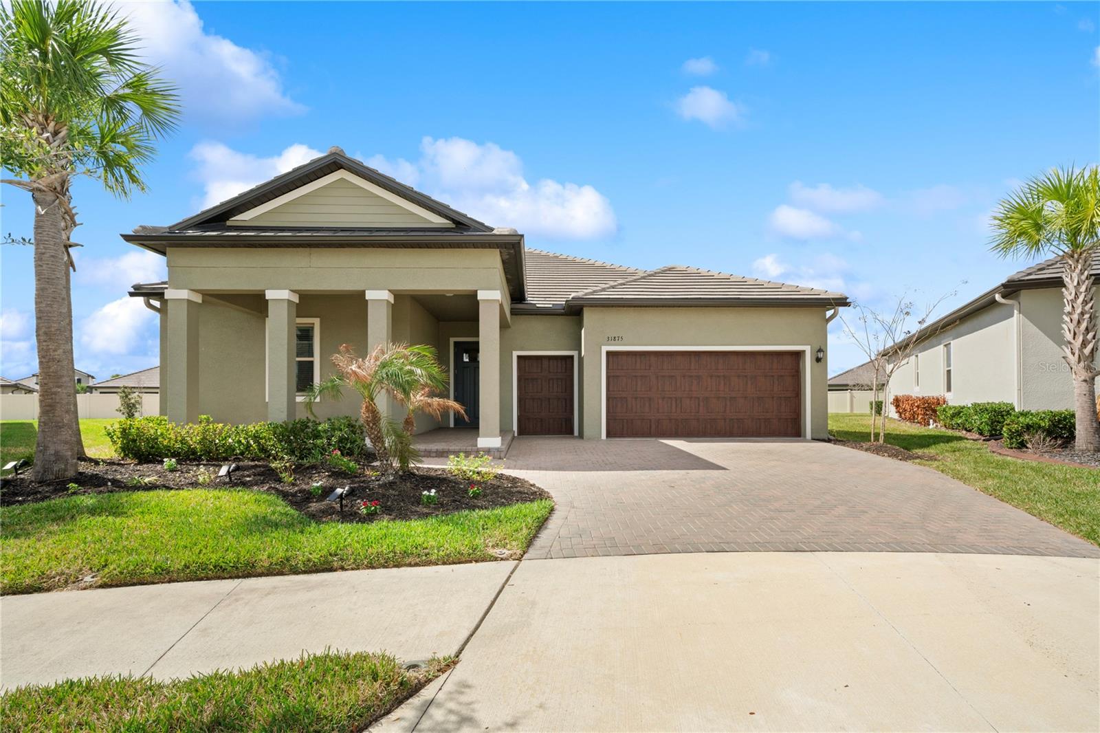 Experience maintenance-free living at its finest in the 55+ gated Medley section of the Mirada Lagoon community. This meticulously maintained “Halos” model offers 3 bedrooms, 2.5 baths, a versatile flex room, and 2,350 square feet of beautifully designed living space, delivering exceptional comfort and value in one of the area’s most sought-after active adult communities. From the moment you arrive, the home impresses with outstanding curb appeal, highlighted by tropical landscaping, a brick paver driveway and walkway, and a welcoming covered front porch, all accented by a durable concrete flat tile roof. Step inside to an elegant foyer with 10-foot tray ceilings that naturally separates the private guest wing featuring two bedrooms and a full bath from the main living areas. The home showcases 7-inch wide plank brown vinyl flooring in the main living spaces, 8-foot interior doors throughout, plush carpeting in the bedrooms and flex room, and granite countertops throughout the home for a cohesive upscale finish. The split-bedroom layout provides privacy for the expansive owner’s suite, complete with a luxurious bath featuring dual sink areas, separate mirrors, drop zone and drawer stack, and a spacious walk-in closet. The state-of-the-art kitchen opens to the great room and features abundant cabinetry, granite counters, under-cabinet lighting, a large center island breakfast bar, a Butler’s pantry, and a walk-in pantry, along with a bright café dining area overlooking the backyard. The great room includes a built-in wine bar with upper and lower cabinets, Granite countertop, and a wine refrigerator, perfect for entertaining. It opens to the screened rear lanai with retractable sun shades, where you can enjoy beautiful Florida sunsets overlooking the fully fenced backyard. A flex room located near the lanai and primary suite is ideal for a home office, den, or guest retreat. Additional highlights include a laundry room with $15K of custom cabinetry, a two-and-a-half-car garage with a separate golf cart garage door, and stairs leading to a second-floor storage room for excellent organization. This move-in-ready home also features energy-efficient systems, including a Carrier 16 SEER air conditioning system. Residents of Medley at Mirada enjoy true maintenance-free living, with services including complete lawn care (mowing, mulching, trimming, blowing, fertilizing, and insect control) plus scheduled exterior painting every seven years. The resort-style Medley community offers exclusive amenities, including a clubhouse, beach-entry pool, pickleball courts, fitness center, ballroom with banquet facilities, and a full calendar of planned classes, activities, events, and excursions. Conveniently located north of Tampa just off a major highway, the community provides easy access to Wesley Chapel, Ocala, Orlando, Lakeland, major airports, and Florida’s beautiful beaches—schedule your private showing today and discover why Medley at Mirada is truly the place to be.